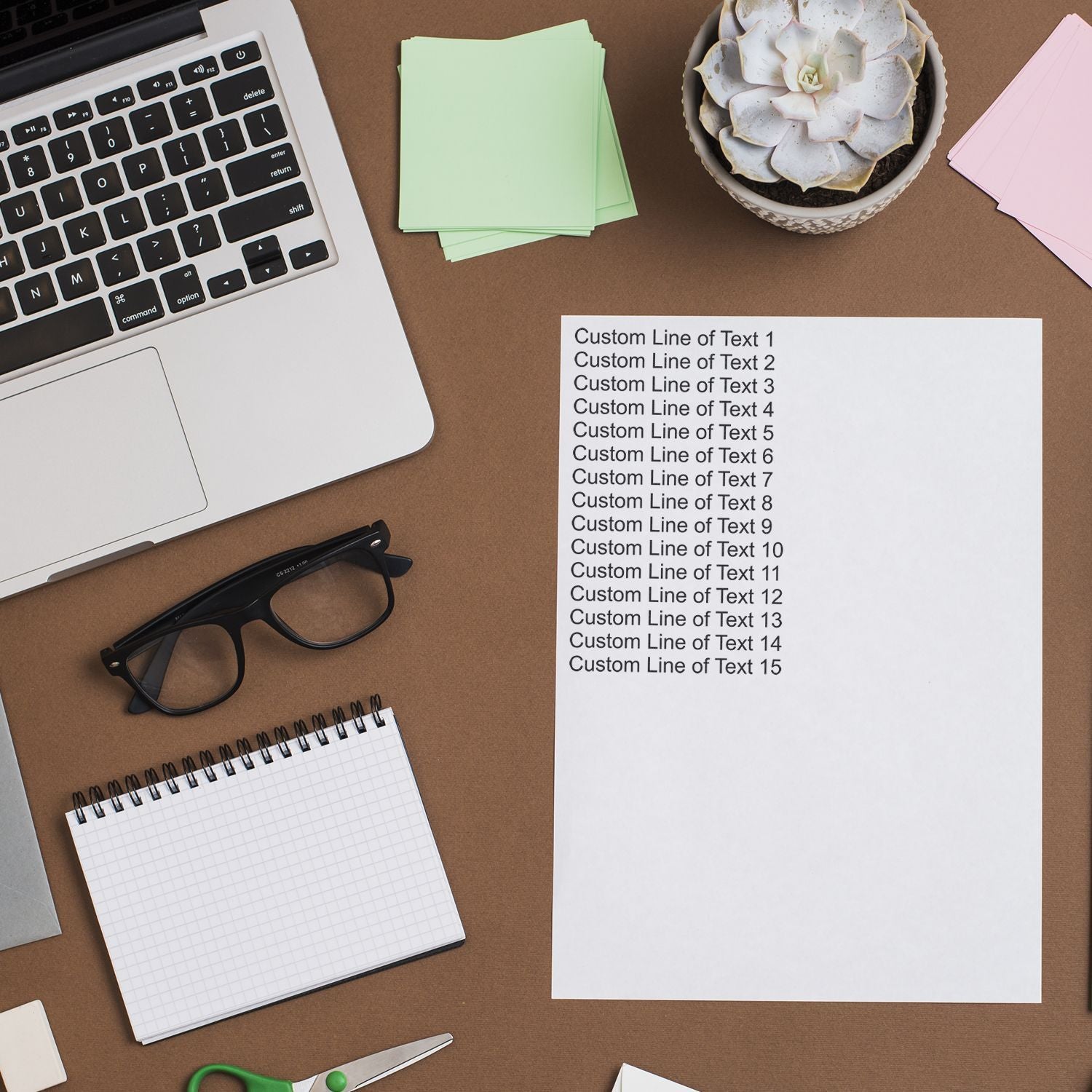 Flat lay office desk with laptop, sticky notes, succulent and blank poster template showing Custom Line of Text lines.