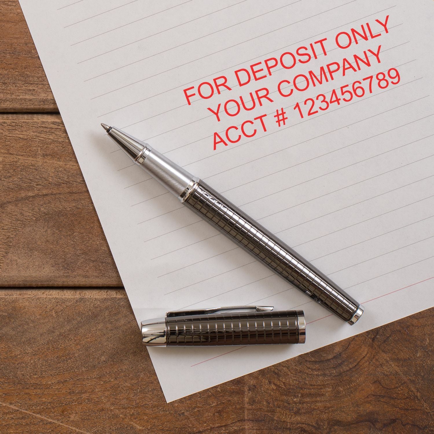 For deposit only stamp on business check with silver pen on wooden desk, banking and accounting concept.