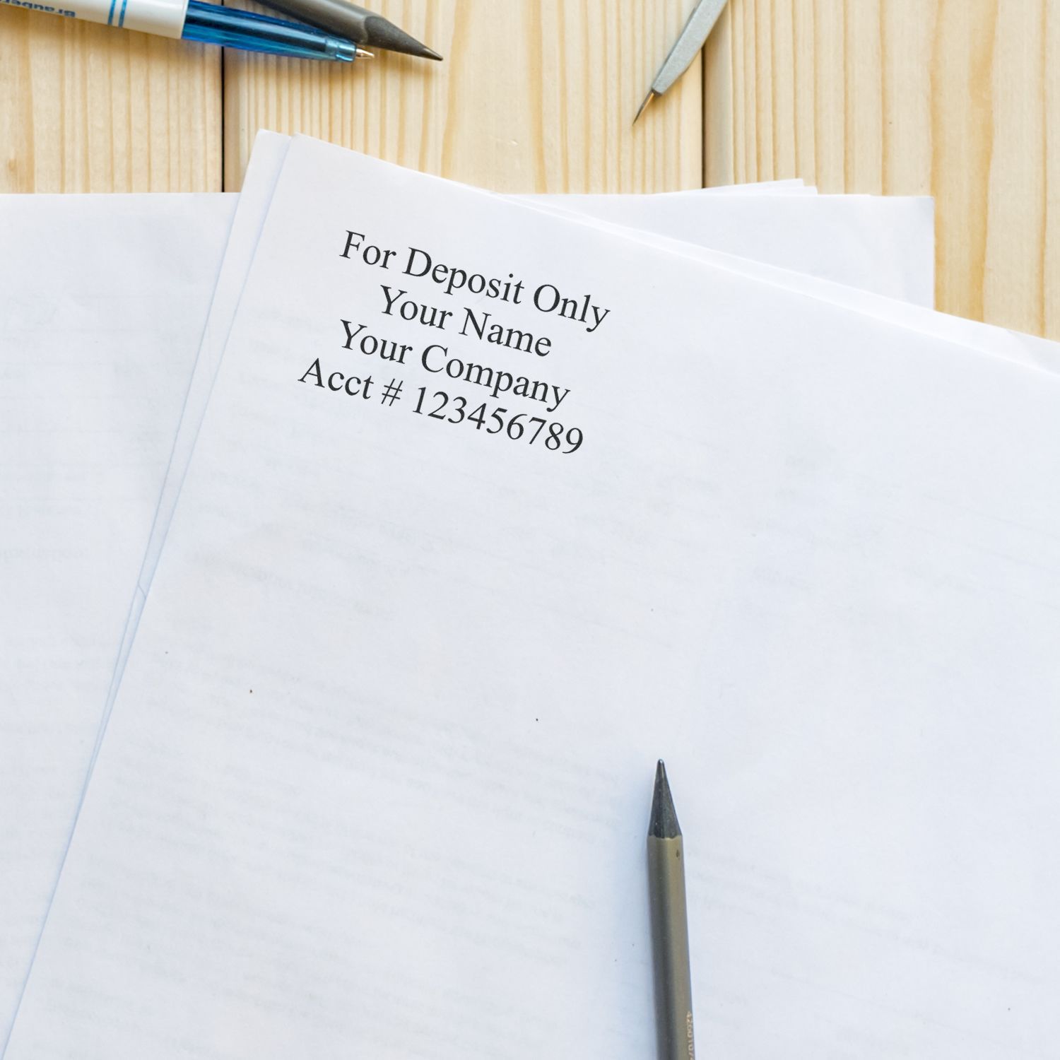 For Deposit Only business check with pens on a wooden desk, banking and financial deposit form concept.
