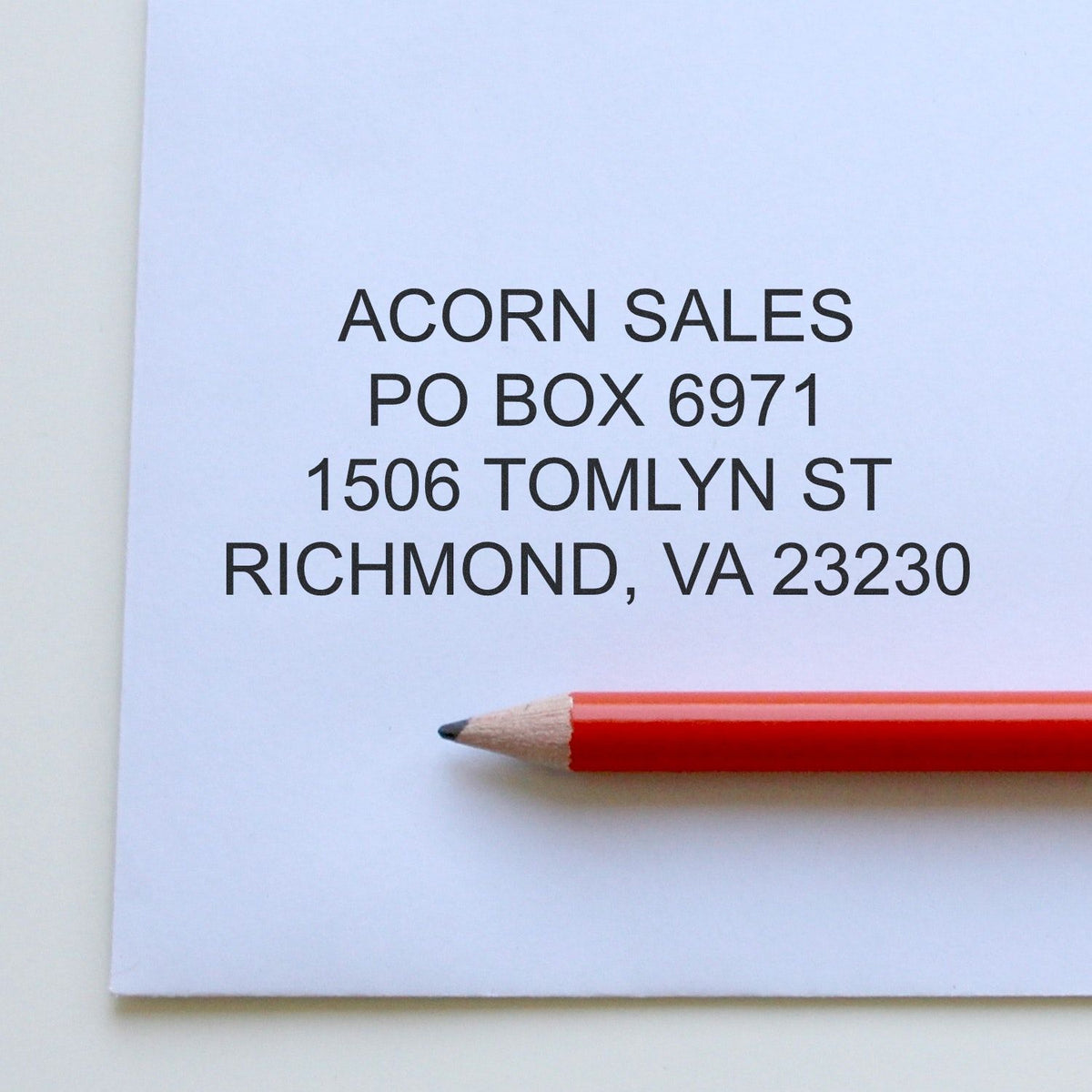 Printed Acorn Sales mailing address on white paper with red pencil, Richmond, VA 23280.