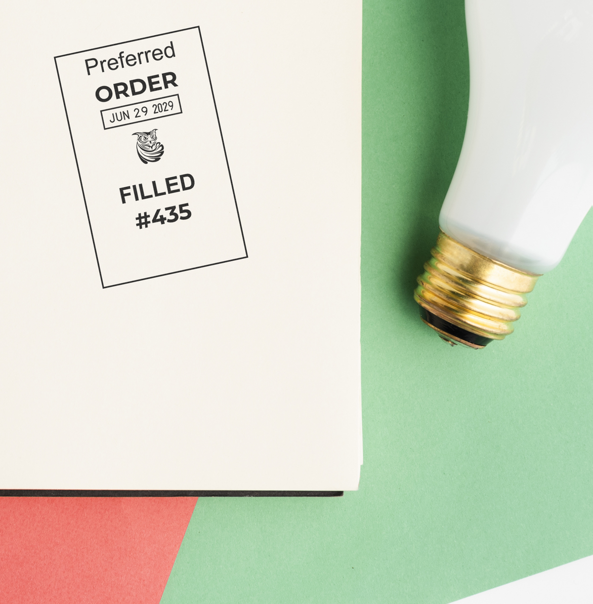 Preferred order filled stamp on a document beside a light bulb on a green and white background.