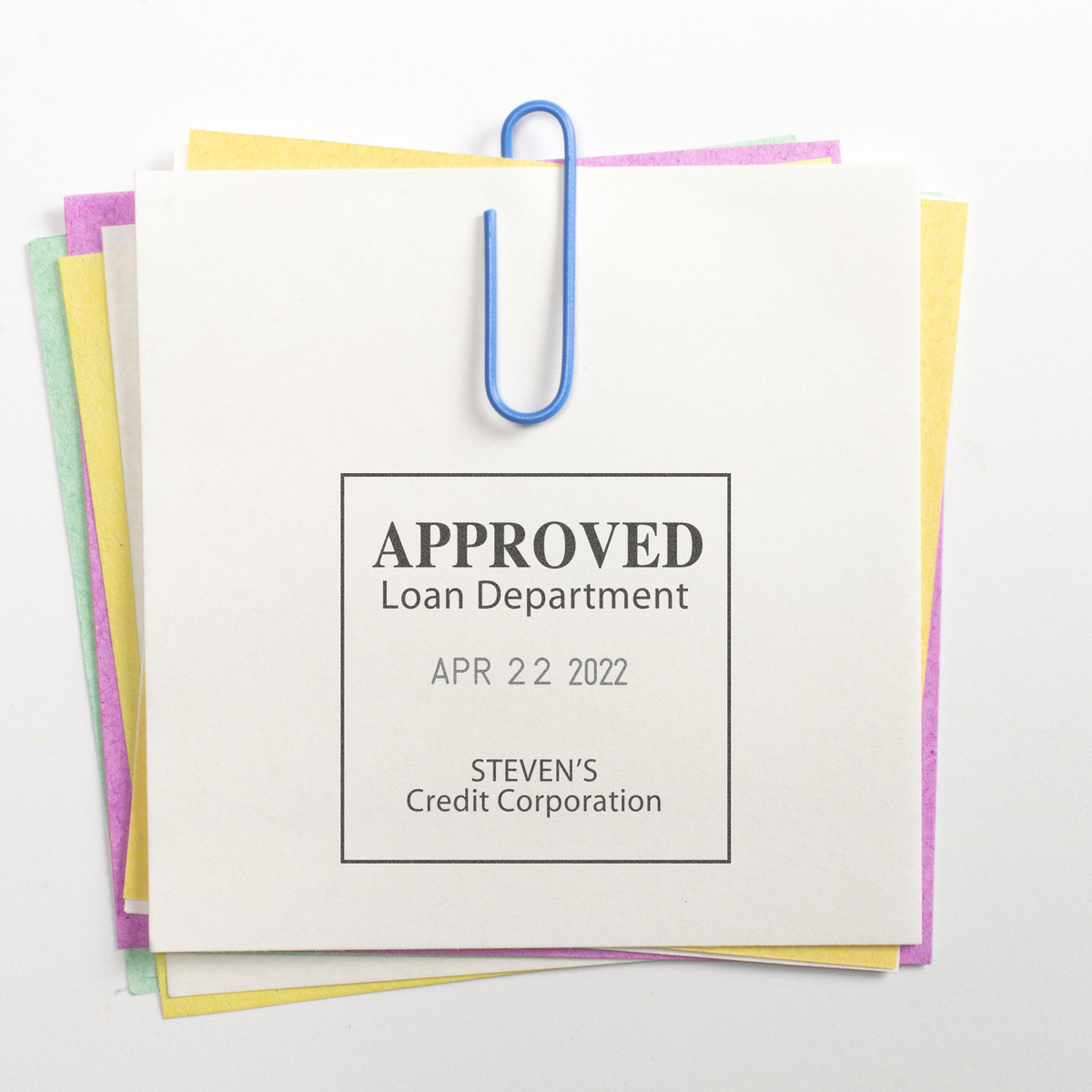 Approved loan department document stack clipped with a blue paper clip, showing Stevens Credit Corporation loan approval notice.