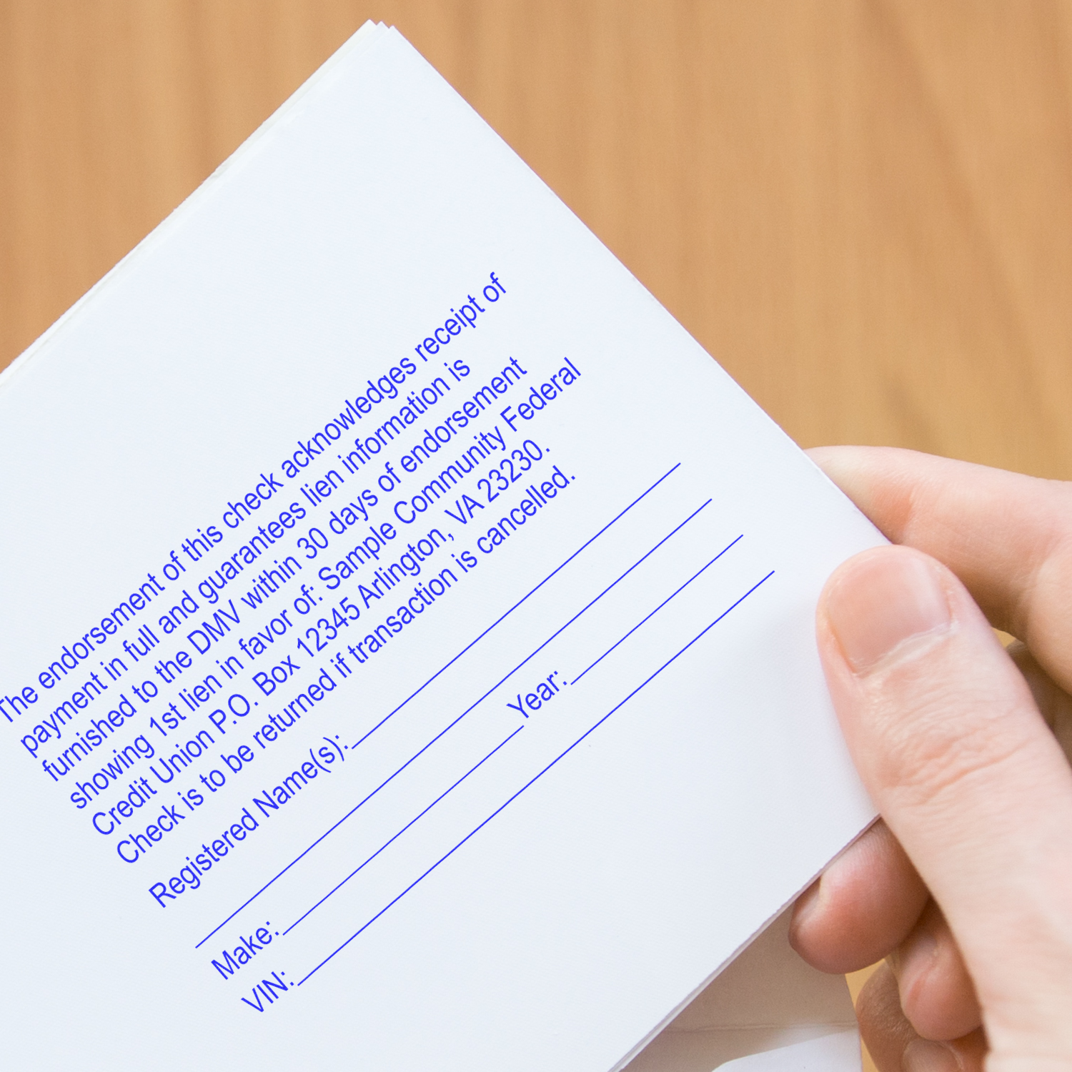 Hand holding a DMV payment and registration check form, showing instructions to submit within 30 days to avoid cancellation fees.