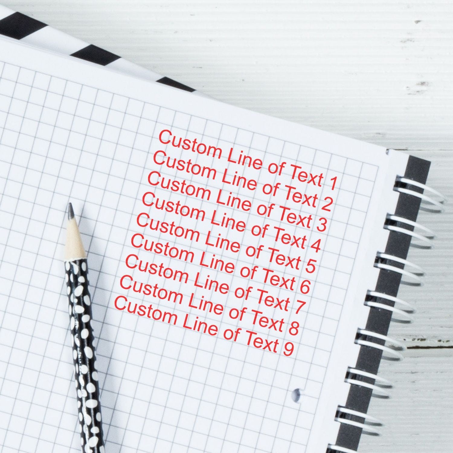 Notebook with grid paper and pencils showing customizable Custom Line of Text placeholder lines for design templates.