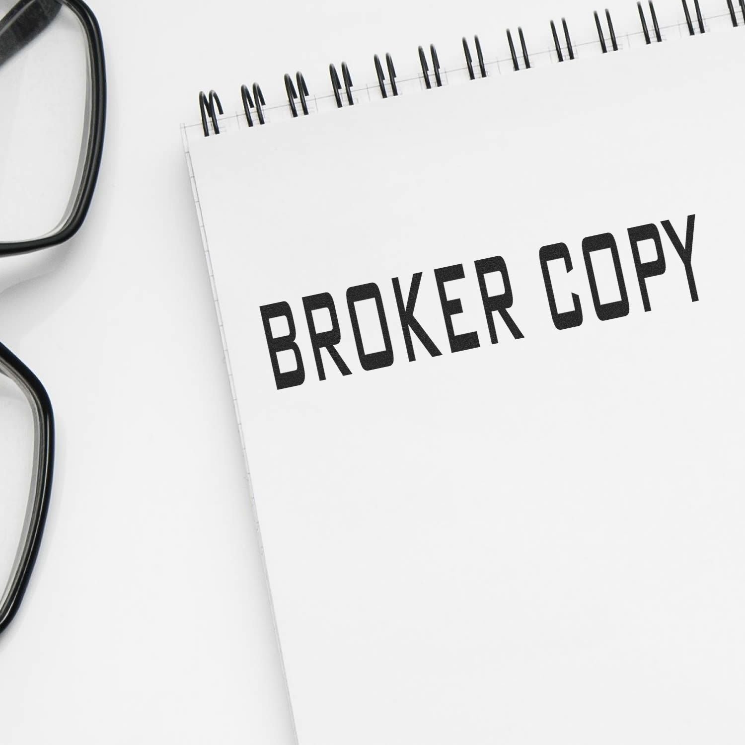 Broker copy concept: eyeglasses over a notepad reading BROKER COPY, symbolizing professional real estate brokerage writing.