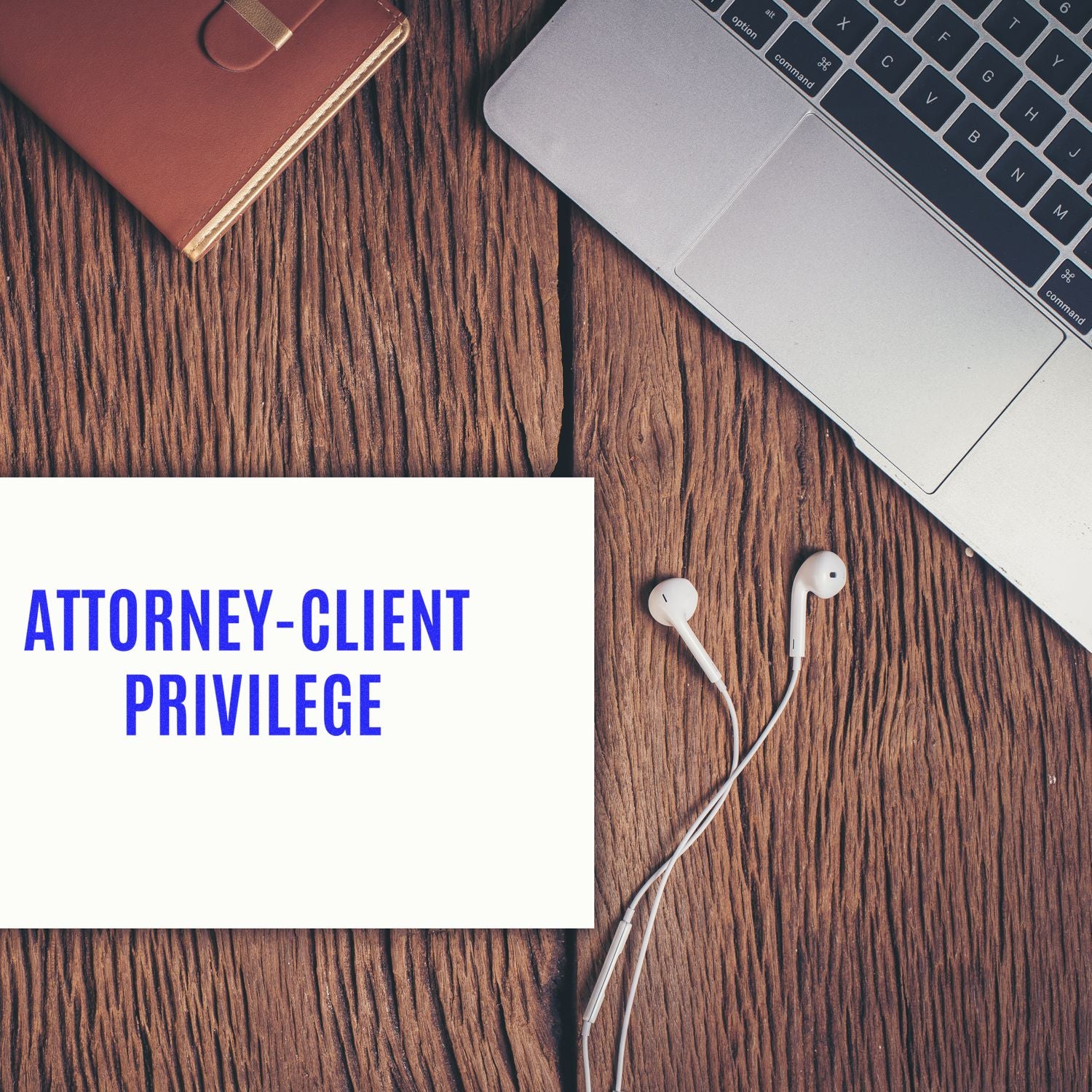 Attorney-client privilege concept on desk with laptop keyboard and headphones; legal protection for confidential client communications.