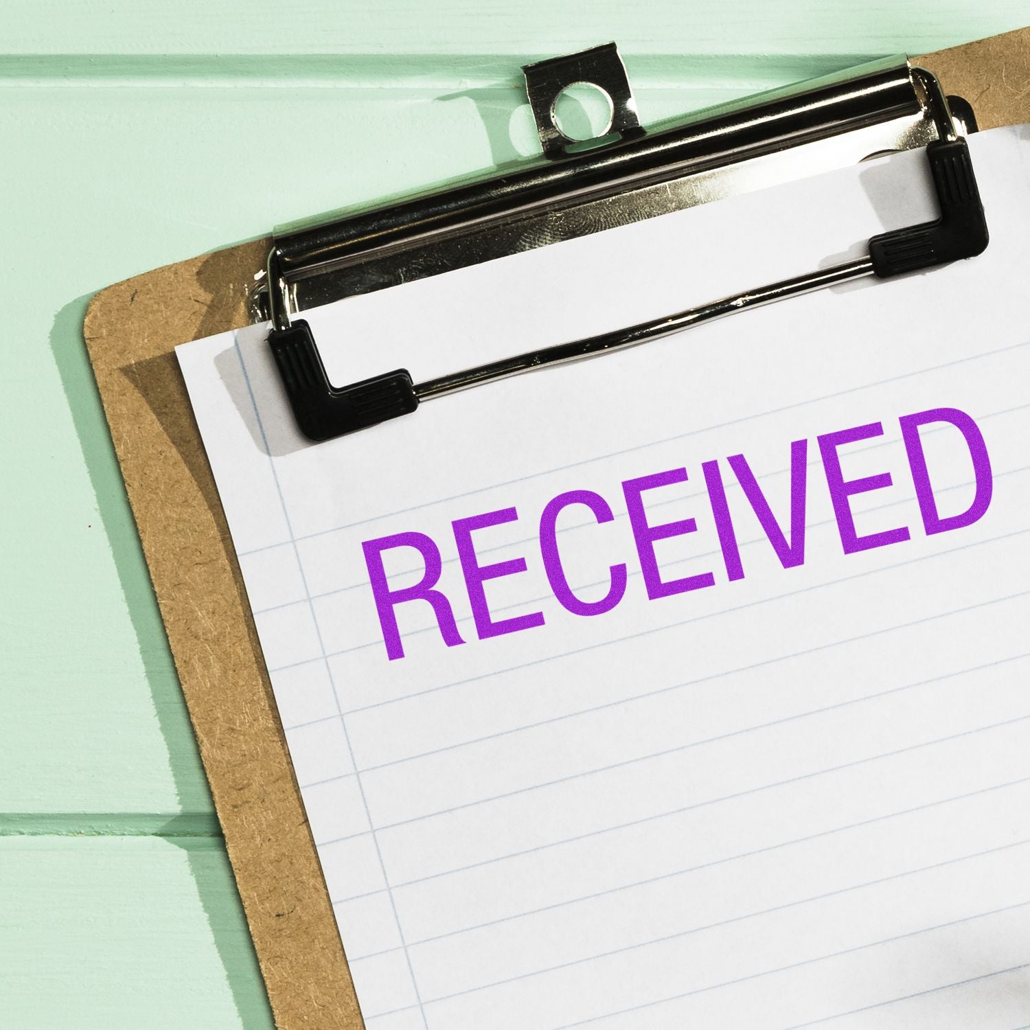 Clipboard paper clipped with bold RECEIVED text, indicating delivery confirmation and receipt of documents or packages.