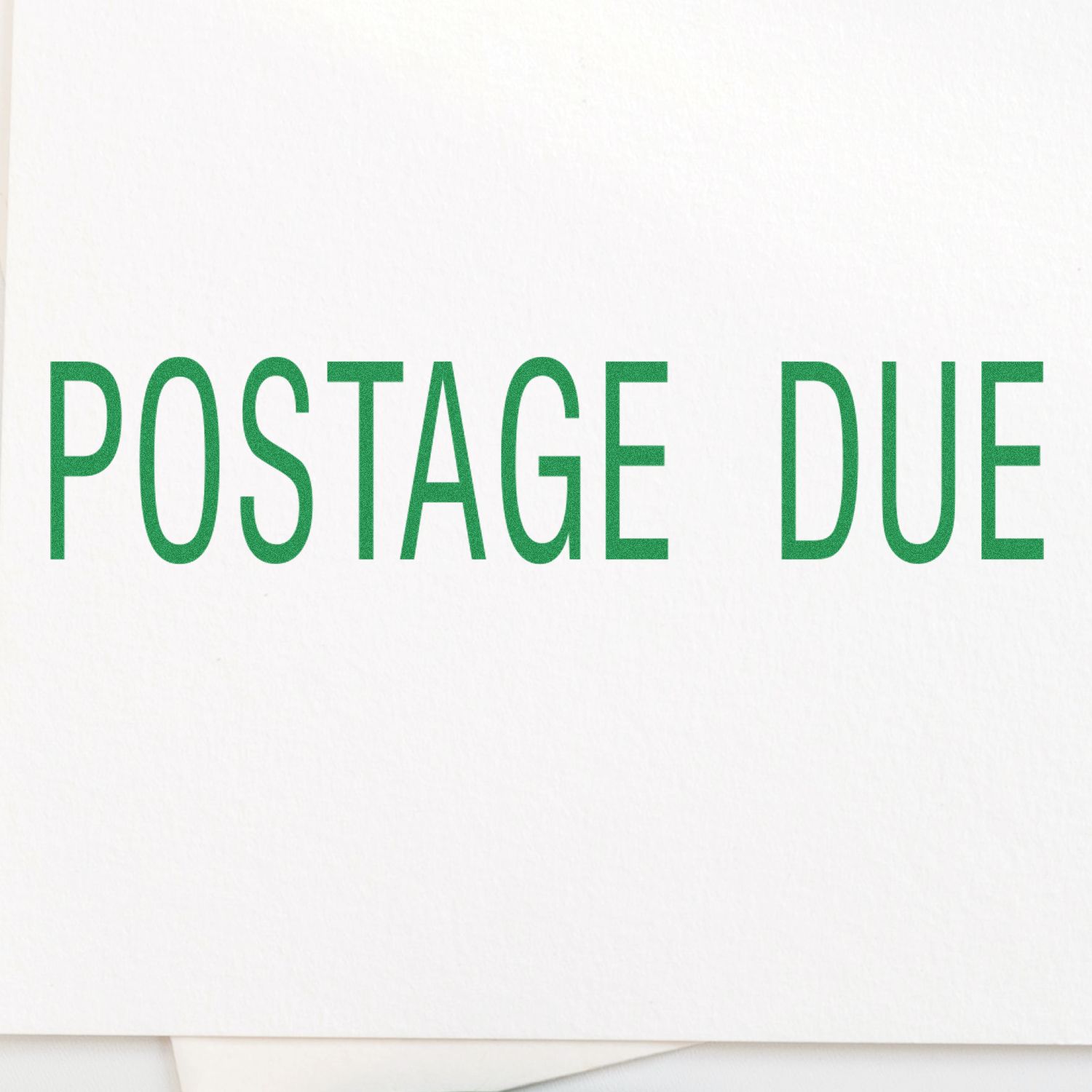 Postage due message on white background with green lettering, postal notice alerting recipients of unpaid shipping fees for mail delivery.