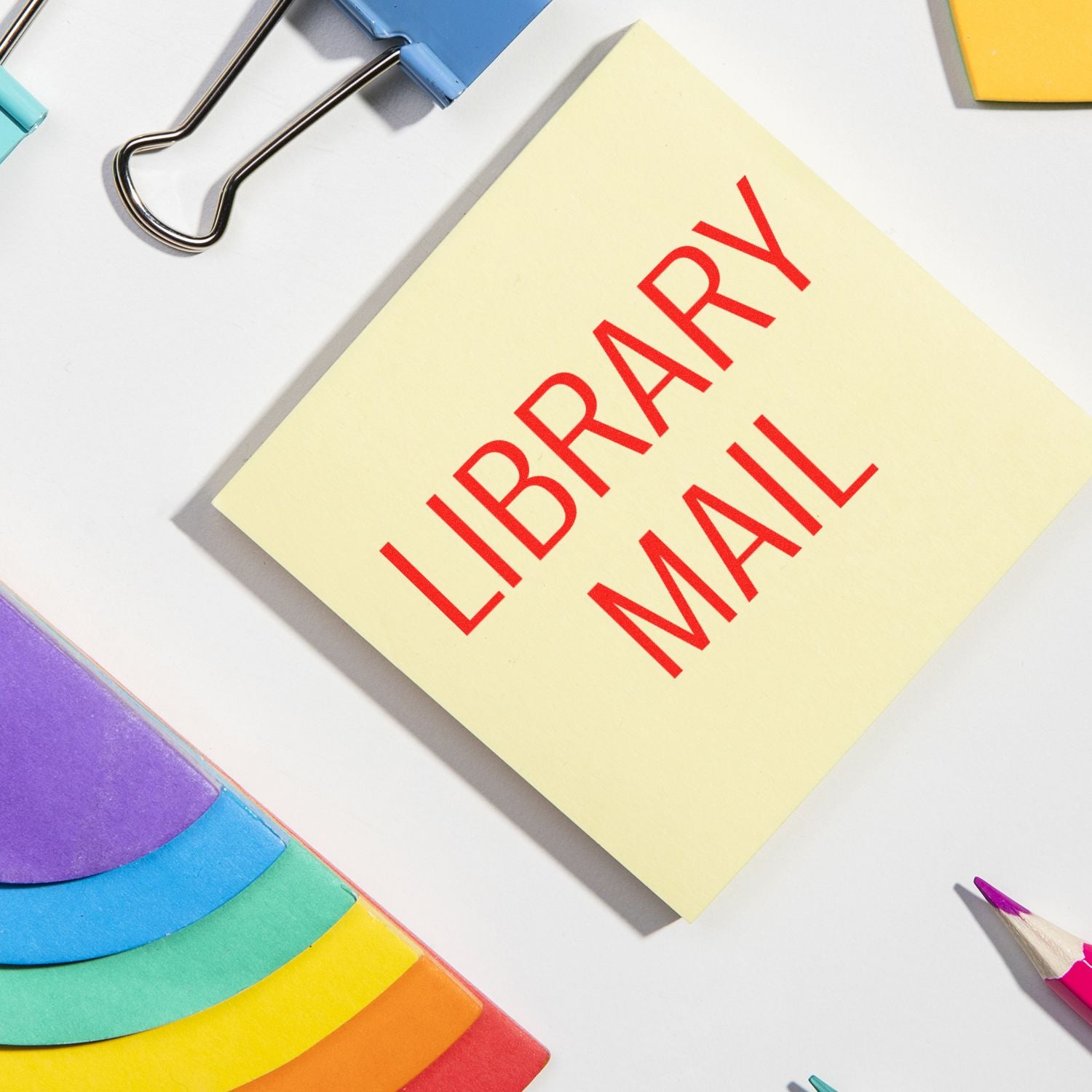 Library anniversary announcement on sticky note with colorful stationery, celebrating reading and community learning.