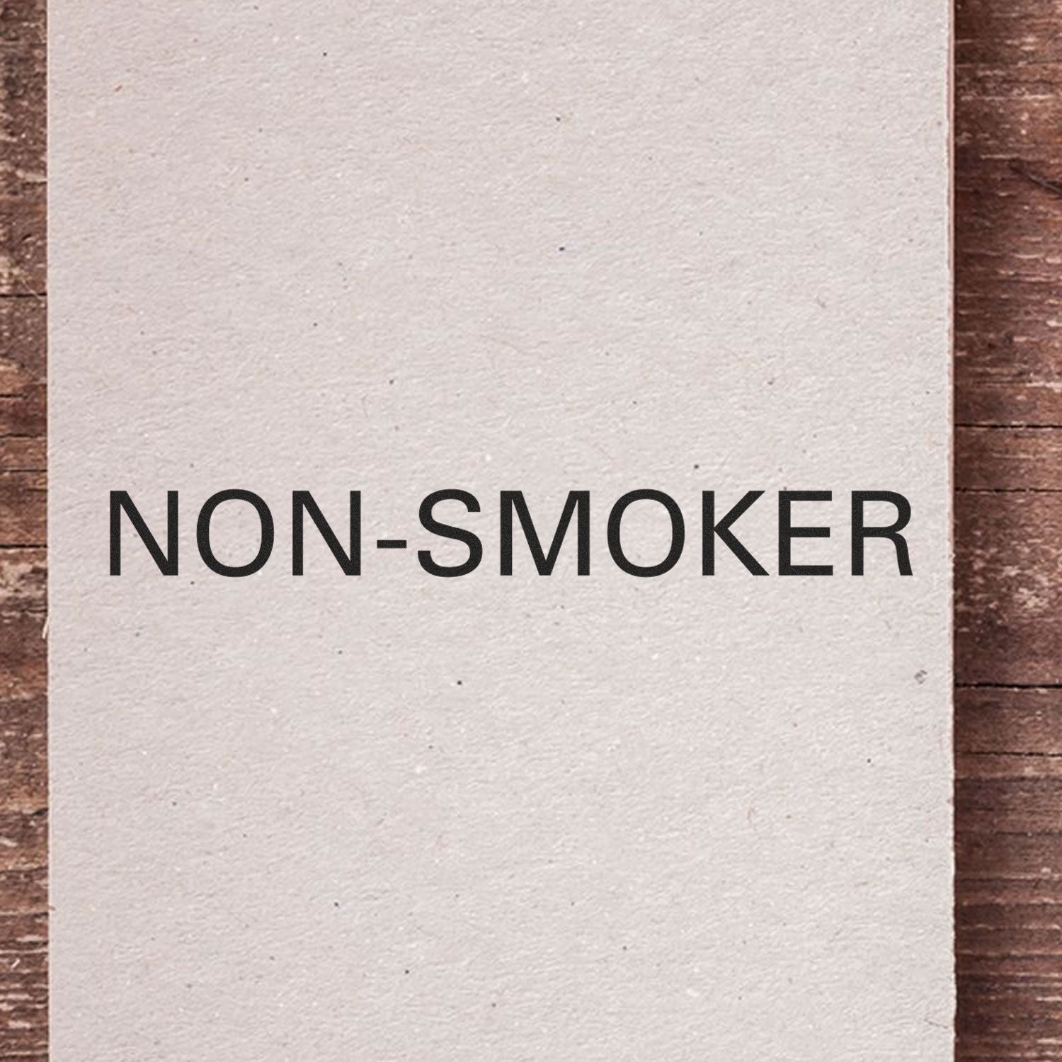 Non-Smoker sign on white wall with bold text, indicating smoking is not allowed in this building area.
