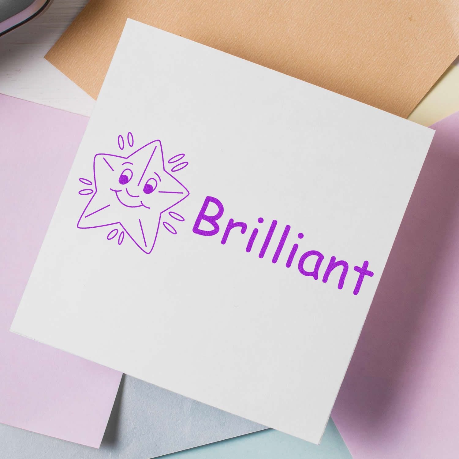 White greeting card with purple Brilliant text and smiling star-cat doodle, colorful stationery for motivational messages.