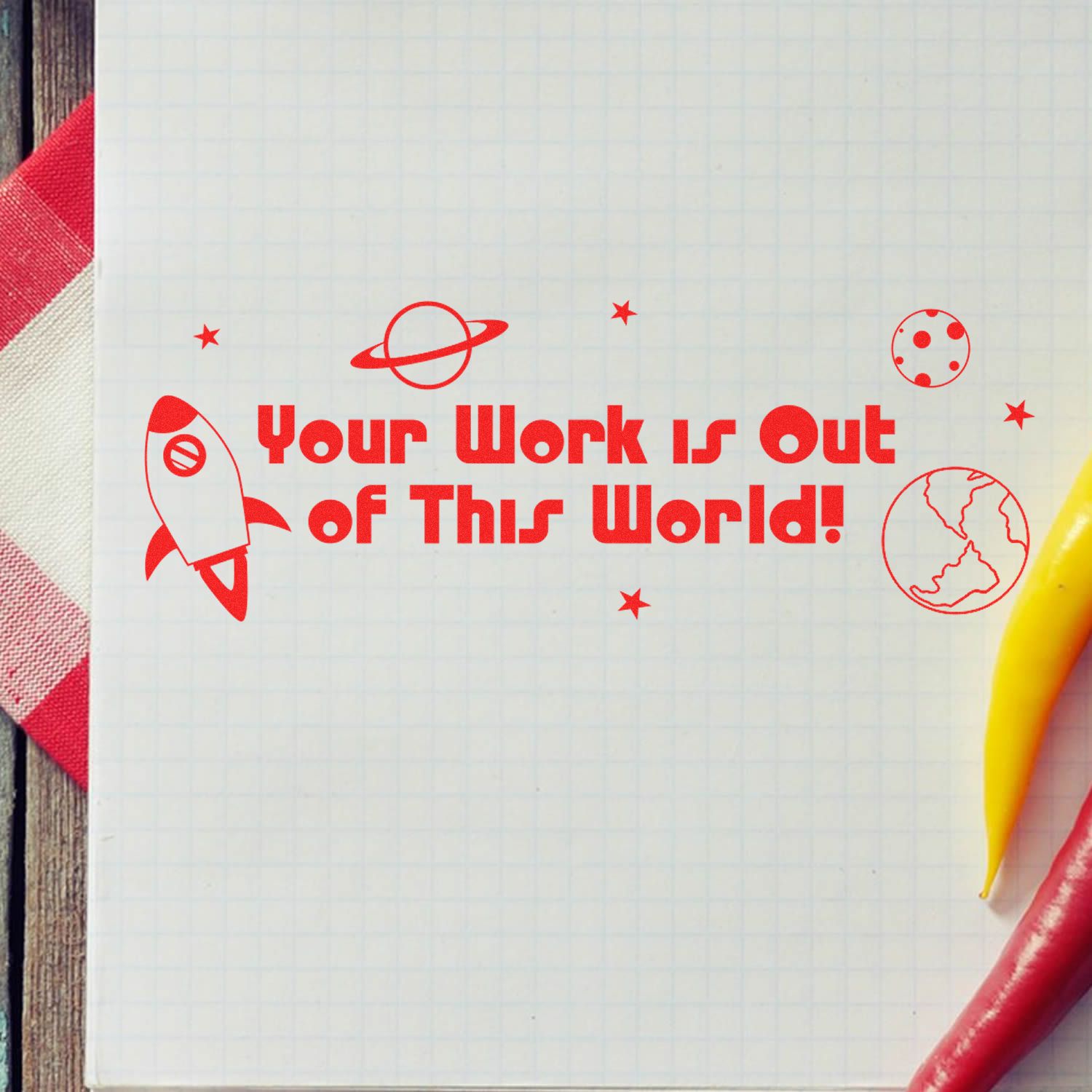 Notebook page with space-themed design reading Your work is out of this world with rocket, stars, planet and pencils.