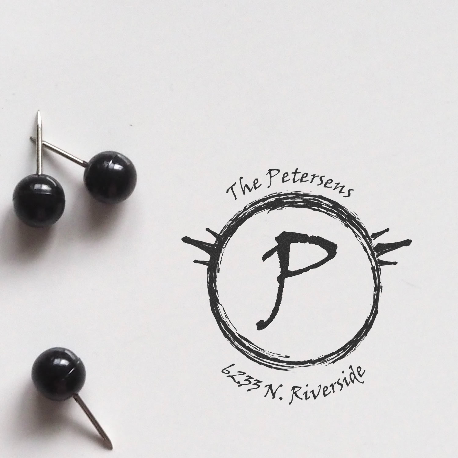 Custom rubber stamp proof for The Petersens featuring a circular monogram logo and address, 6233 N. Riverside.