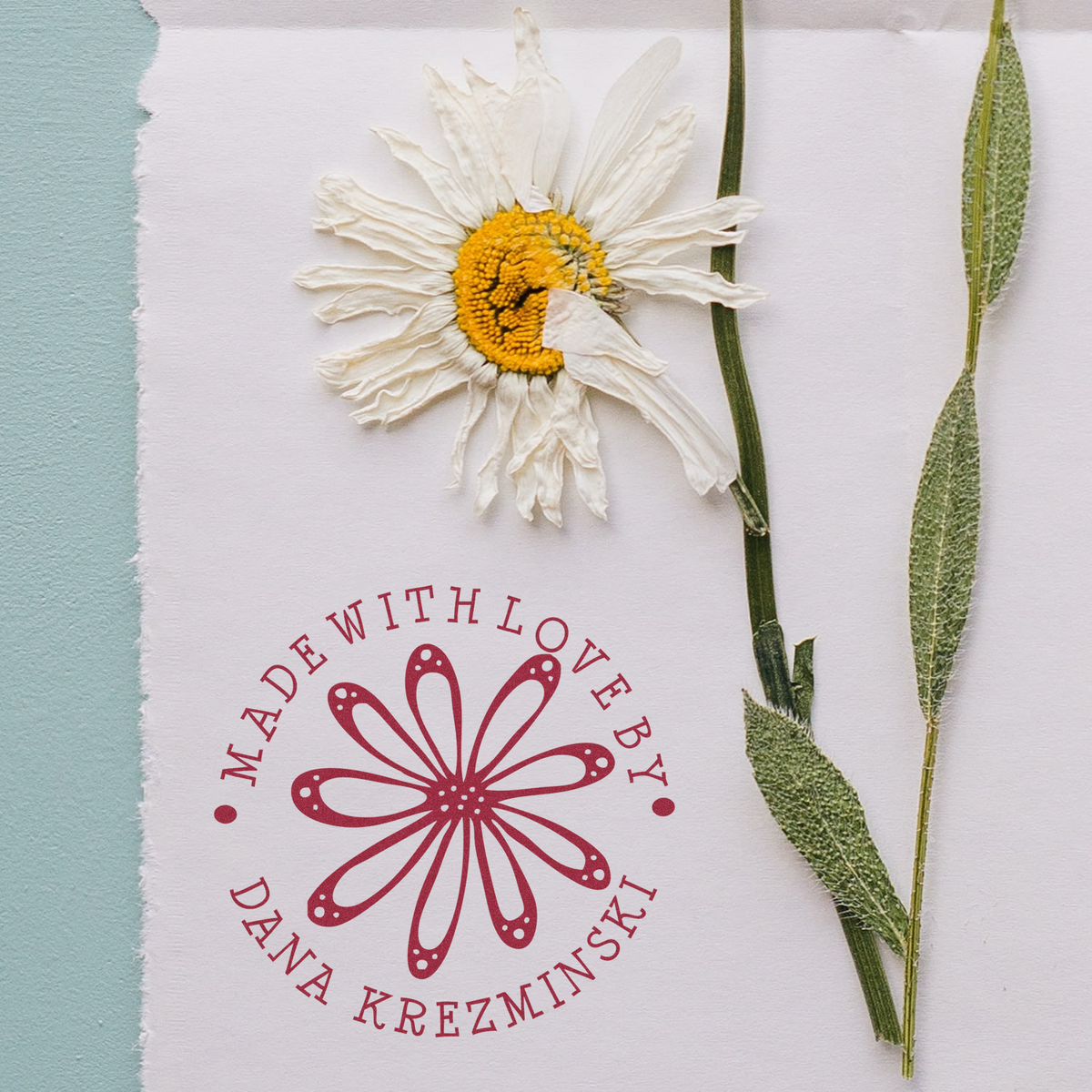 Custom rubber stamp with daisy logo and Made with Love by Dana Krezminski for handmade packaging.