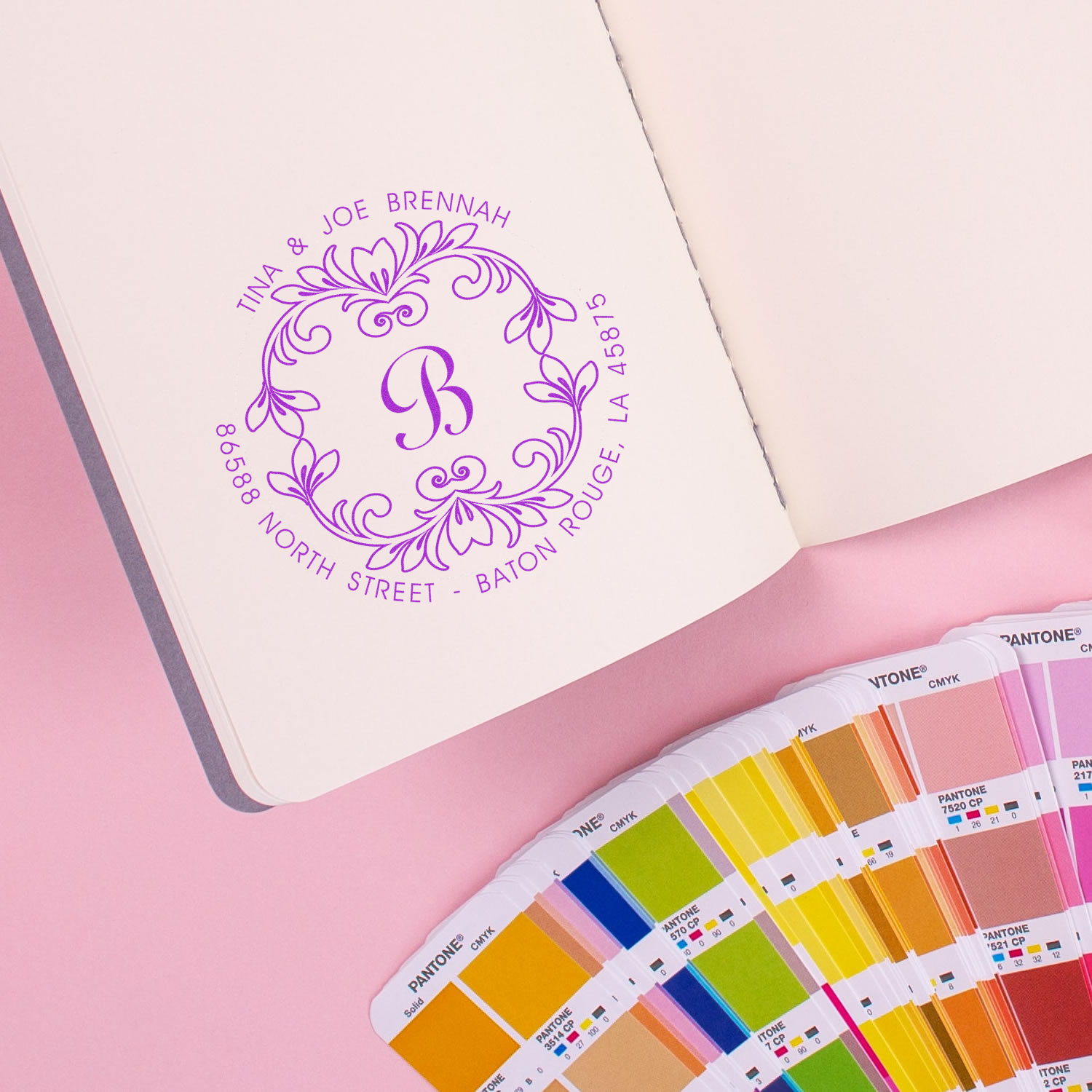 Custom rubber stamp with floral monogram and return address, shown in purple ink with Pantone color swatches.