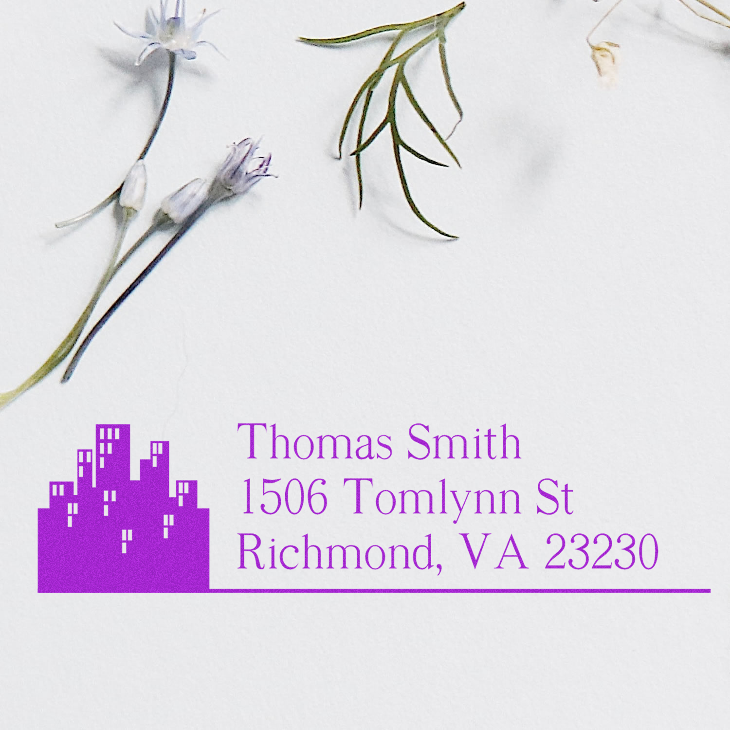 Custom rubber return address stamp with skyline logo and Thomas Smith, 1506 Tomlynn St, Richmond, VA 23230 in purple ink.
