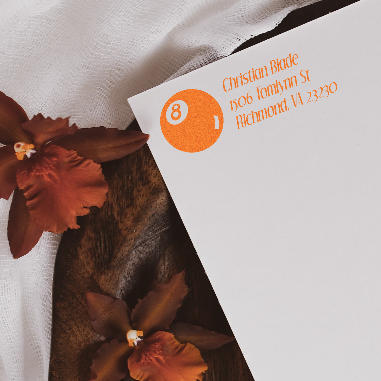 Custom rubber address stamp on stationery featuring Richmond, VA contact details and orange logo for elegant business branding.