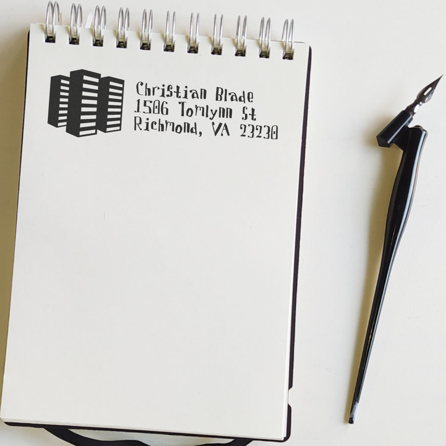 Custom rubber address stamp with logo and return address, shown on paper for business mailing and branding.