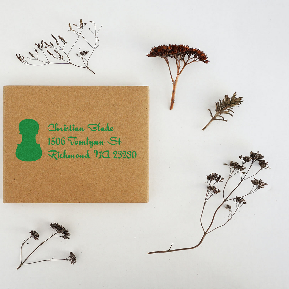 Custom address rubber stamp on kraft box, showing green return address imprint for packaging and branding.