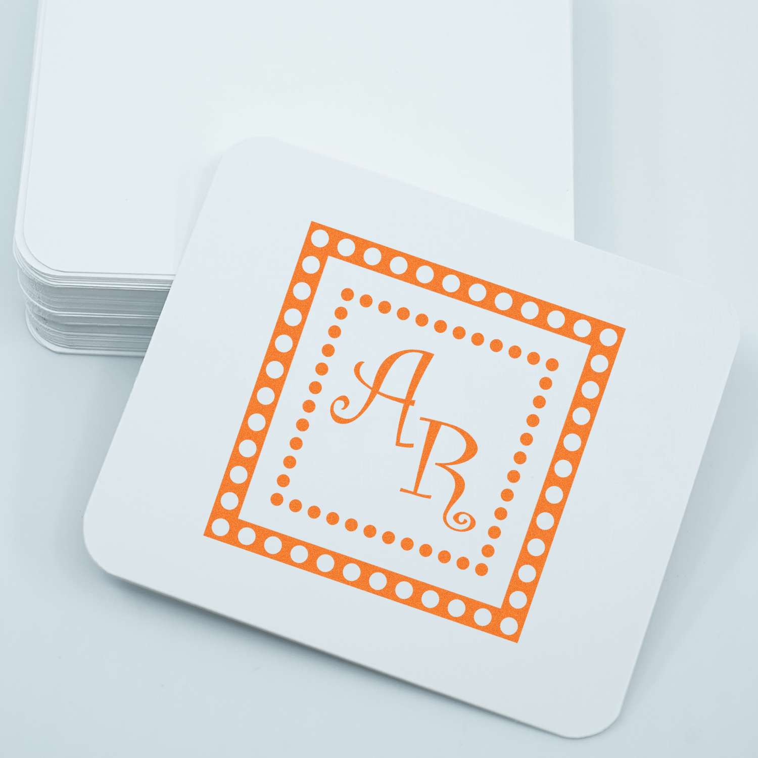 Custom monogram rubber stamp with orange AR initials and dotted border for personalized stationery and branding