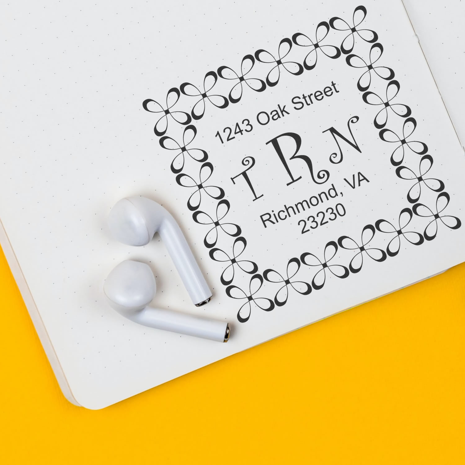 Custom return address rubber stamp with monogram on notebook, ideal for personalized stationery and envelope labeling.