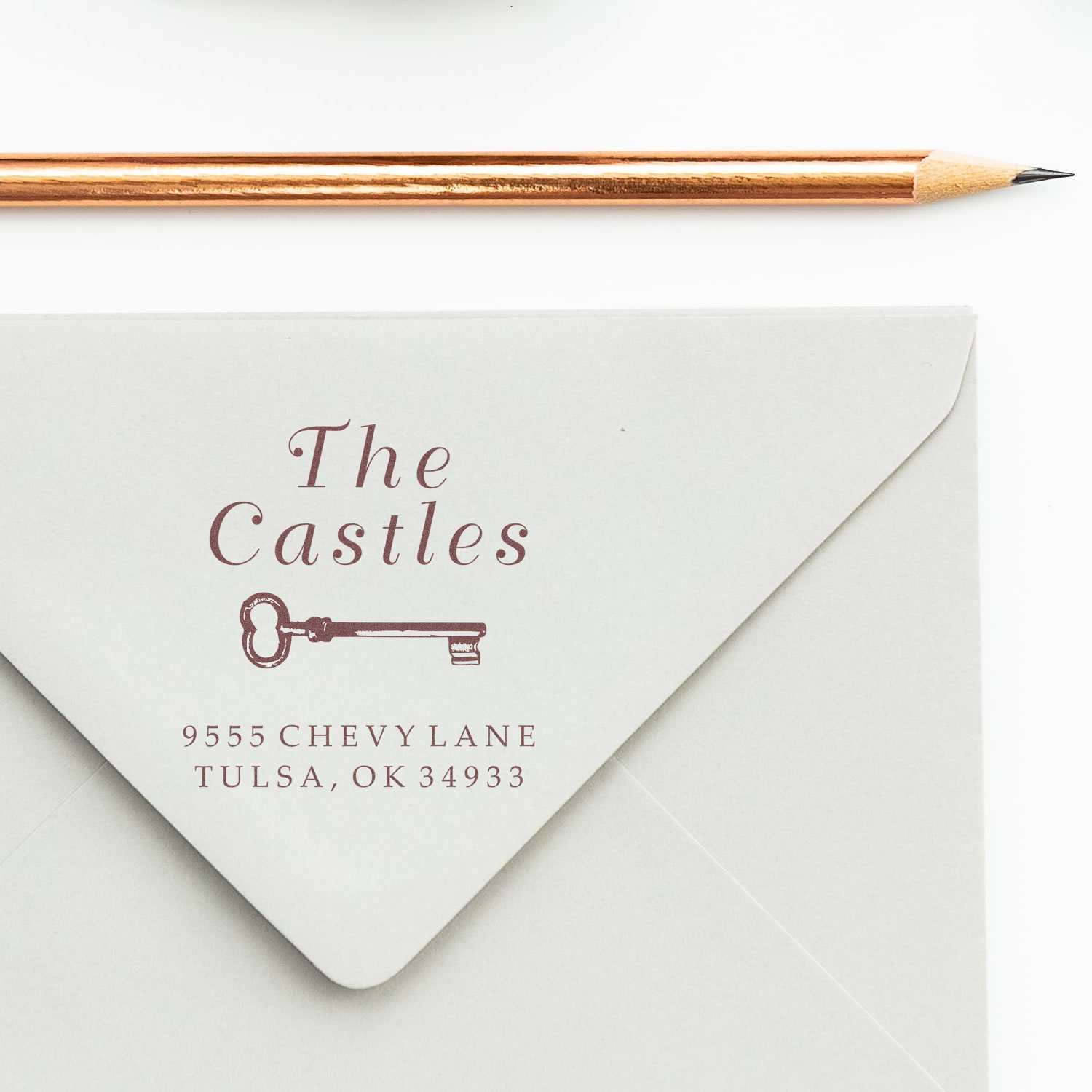 Custom family return address rubber stamp for envelopes, featuring The Castles name, key icon, and address.
