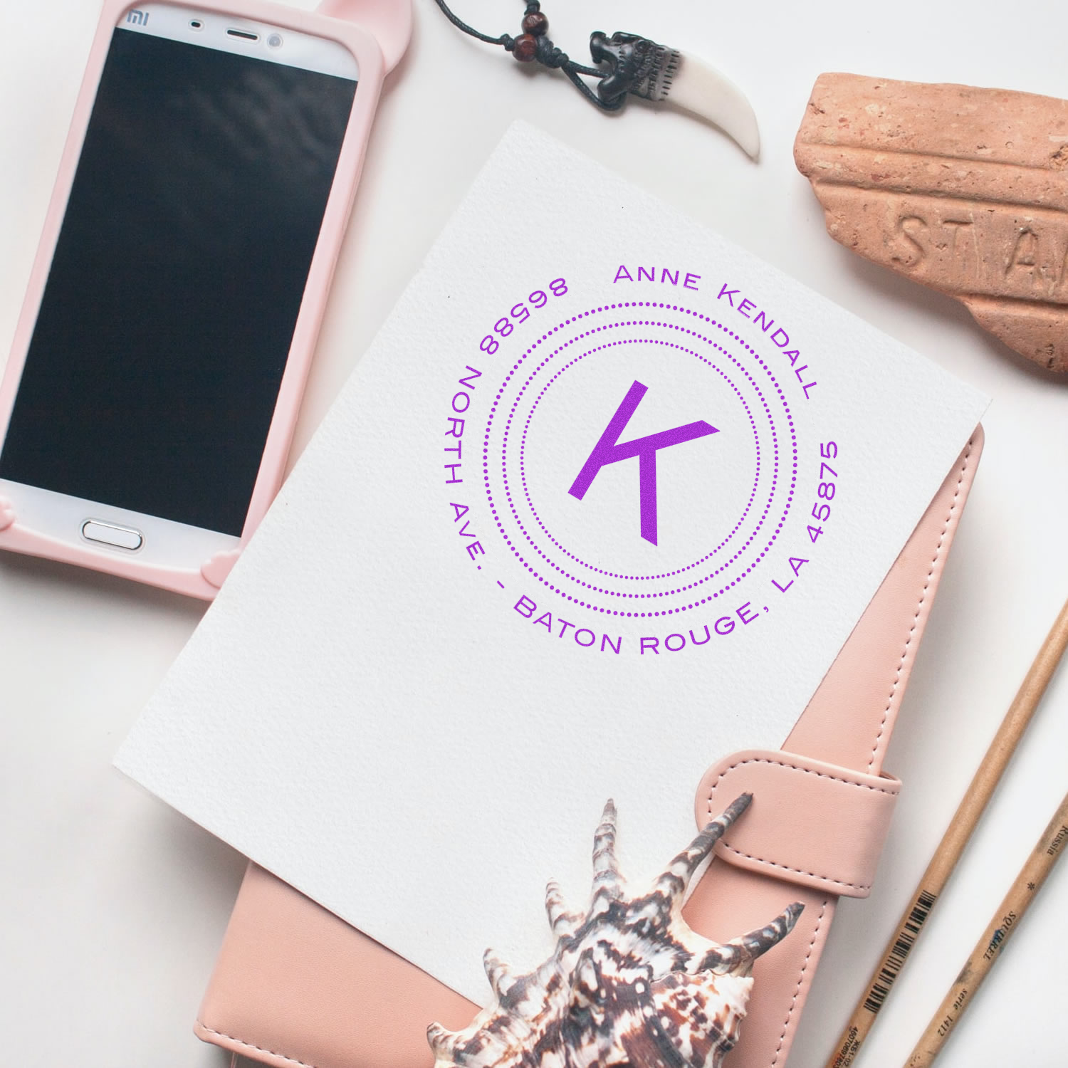 Personalized rubber stamp logo mockup on stationery featuring a monogram for custom business branding.