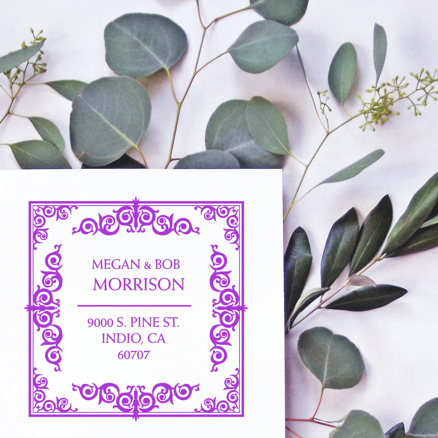 Custom return address rubber stamp with ornate purple border, featuring Megan & Bob Morrisons name and Indio, CA address.