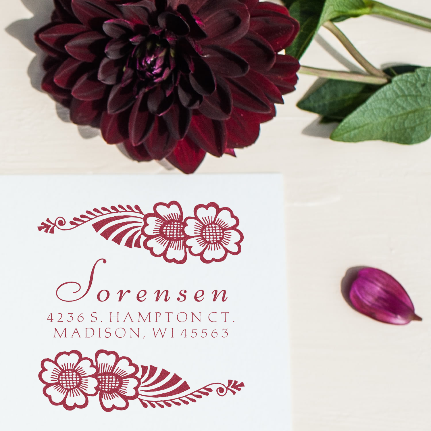Custom floral return address rubber stamp with decorative flower design and script name for wedding stationery.