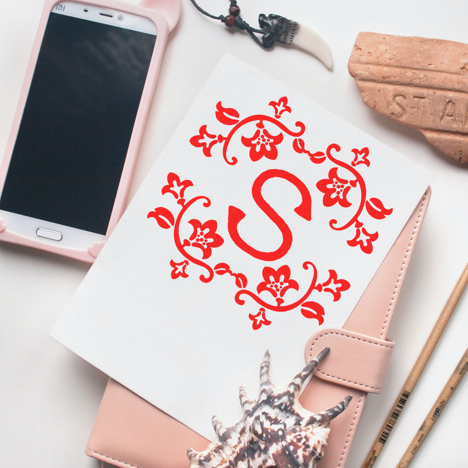 Floral monogram S rubber stamp design on stationery, ideal for personalized wedding invitations, packaging, and craft projects.