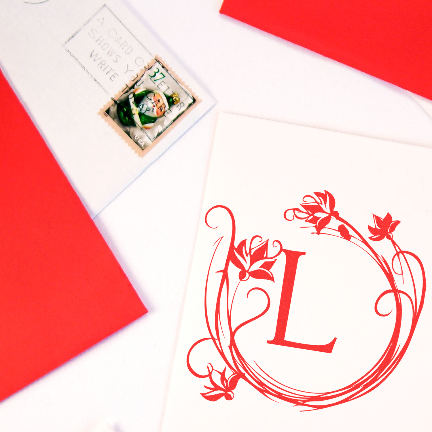 White greeting card envelope with commemorative US postage stamp and red floral cat illustration, ready to mail.