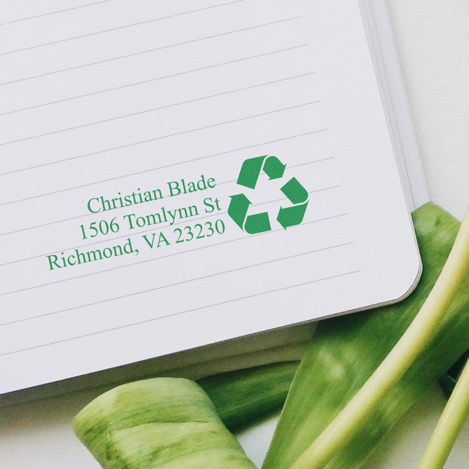 Eco-friendly custom return address rubber stamp with recycle icon, printed in green ink on lined paper