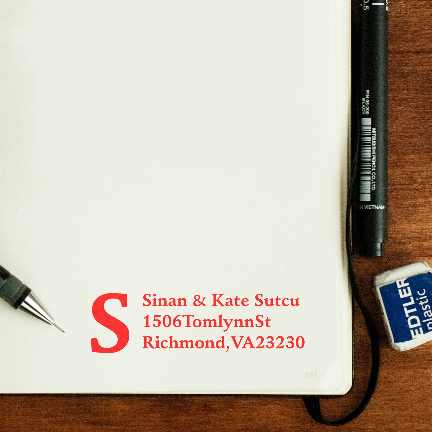 Custom address rubber stamp mockup with monogram and return address on notebook page for personalized stationery.