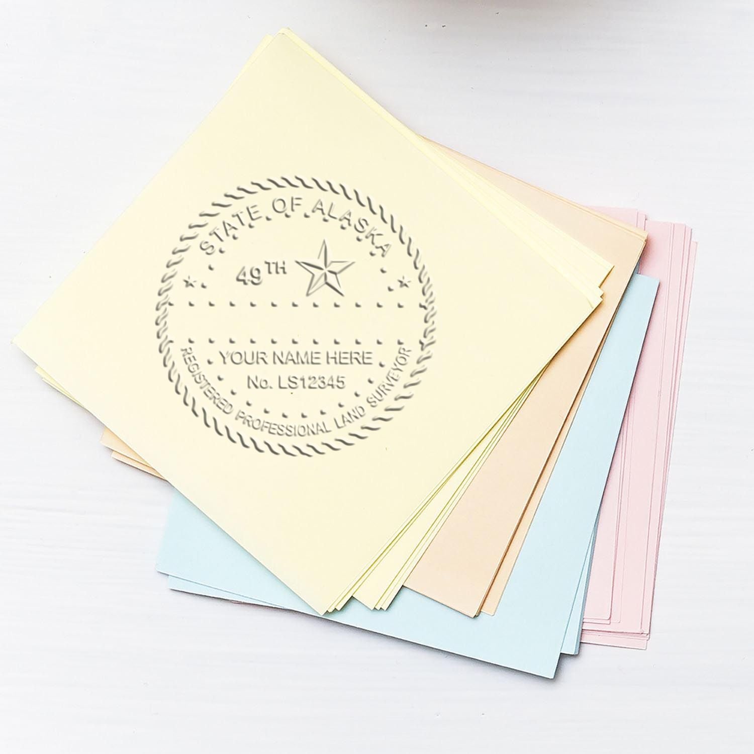 Pastel colored State of Alaska land surveyor certificate folders with embossed professional license seal.