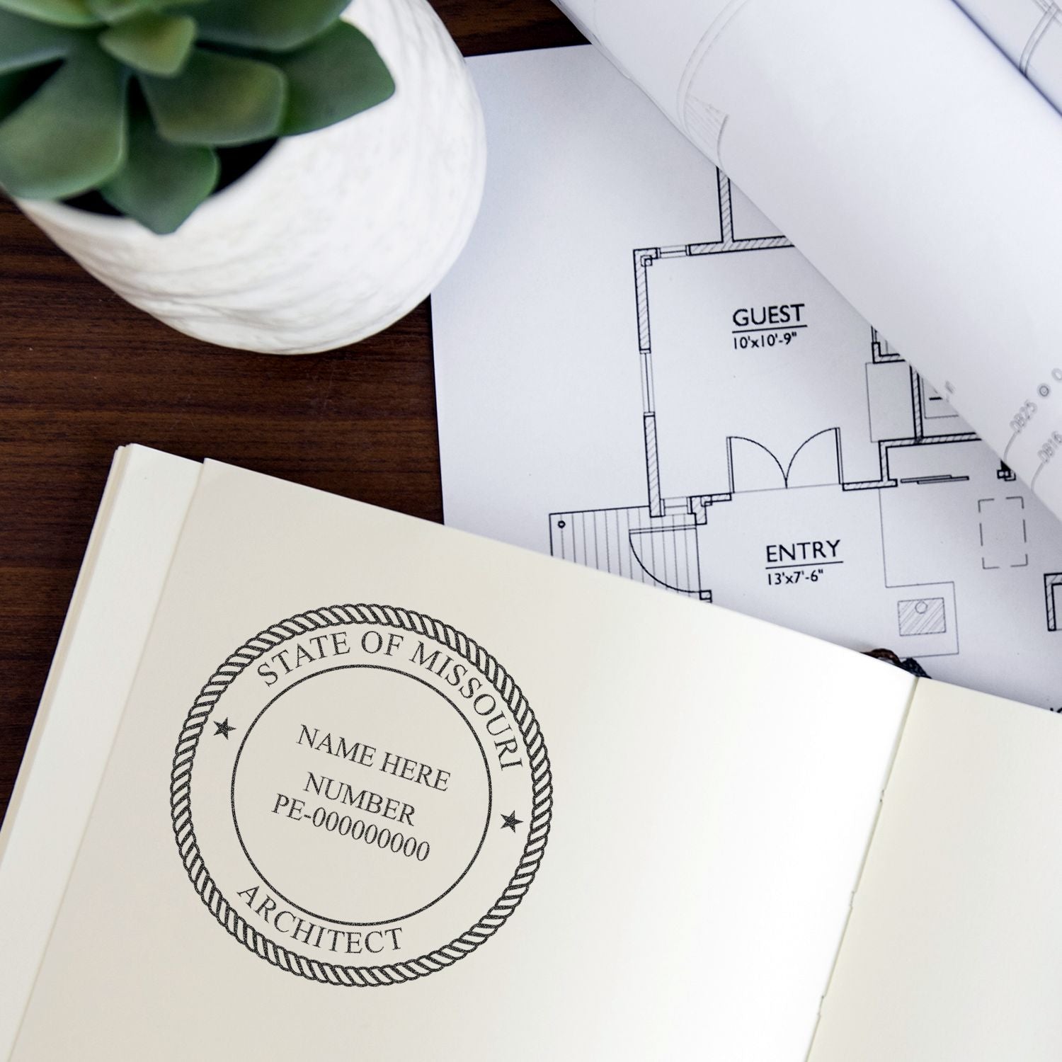 Architectural floor plans with Missouri architect seal on desk, blueprint and design documents with plant.