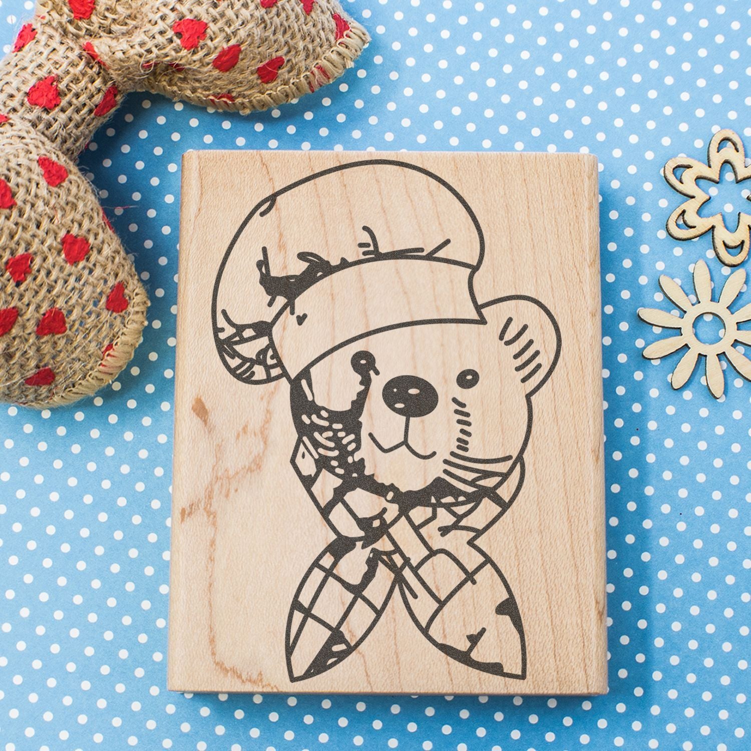 Cute teddy bear stamp on a wooden block with blue polka dot background and rustic craft decor