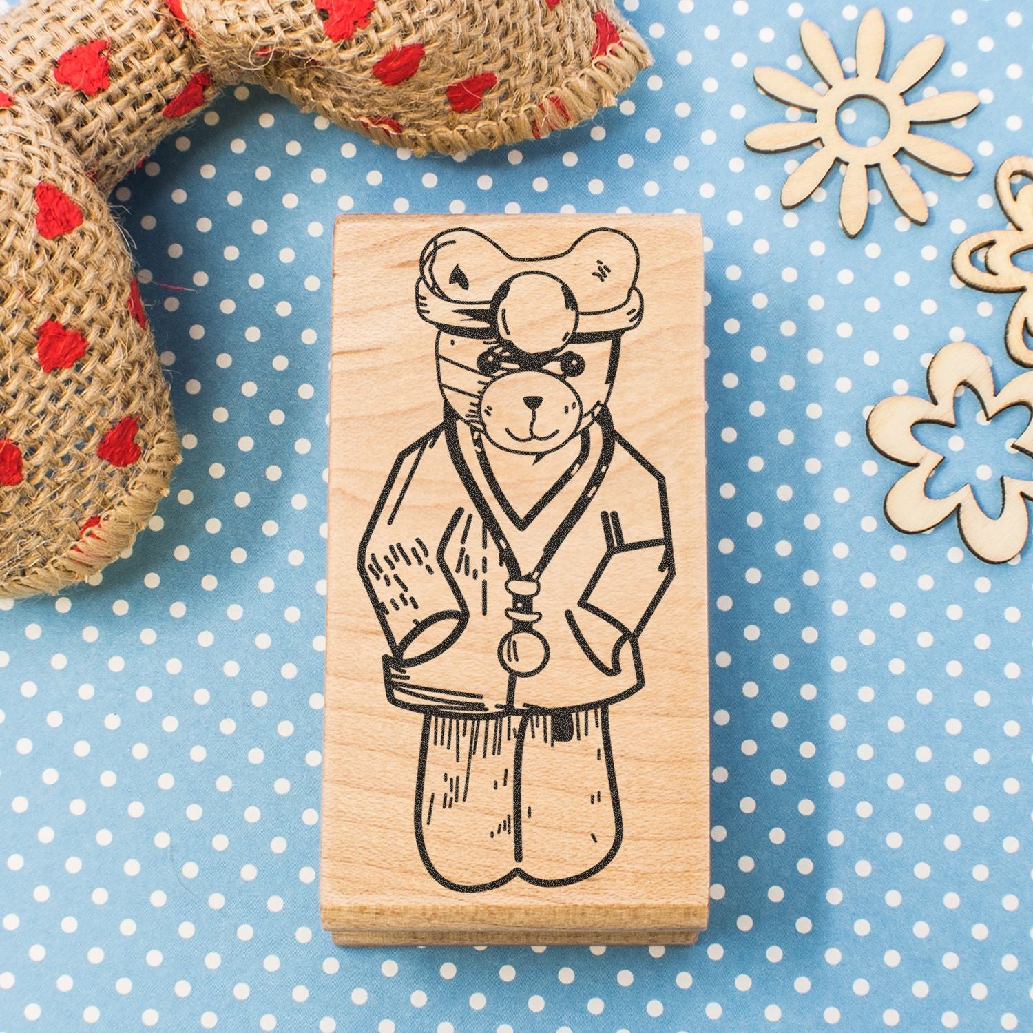 Wooden rubber stamp with cute bear illustration on a blue polka dot craft background