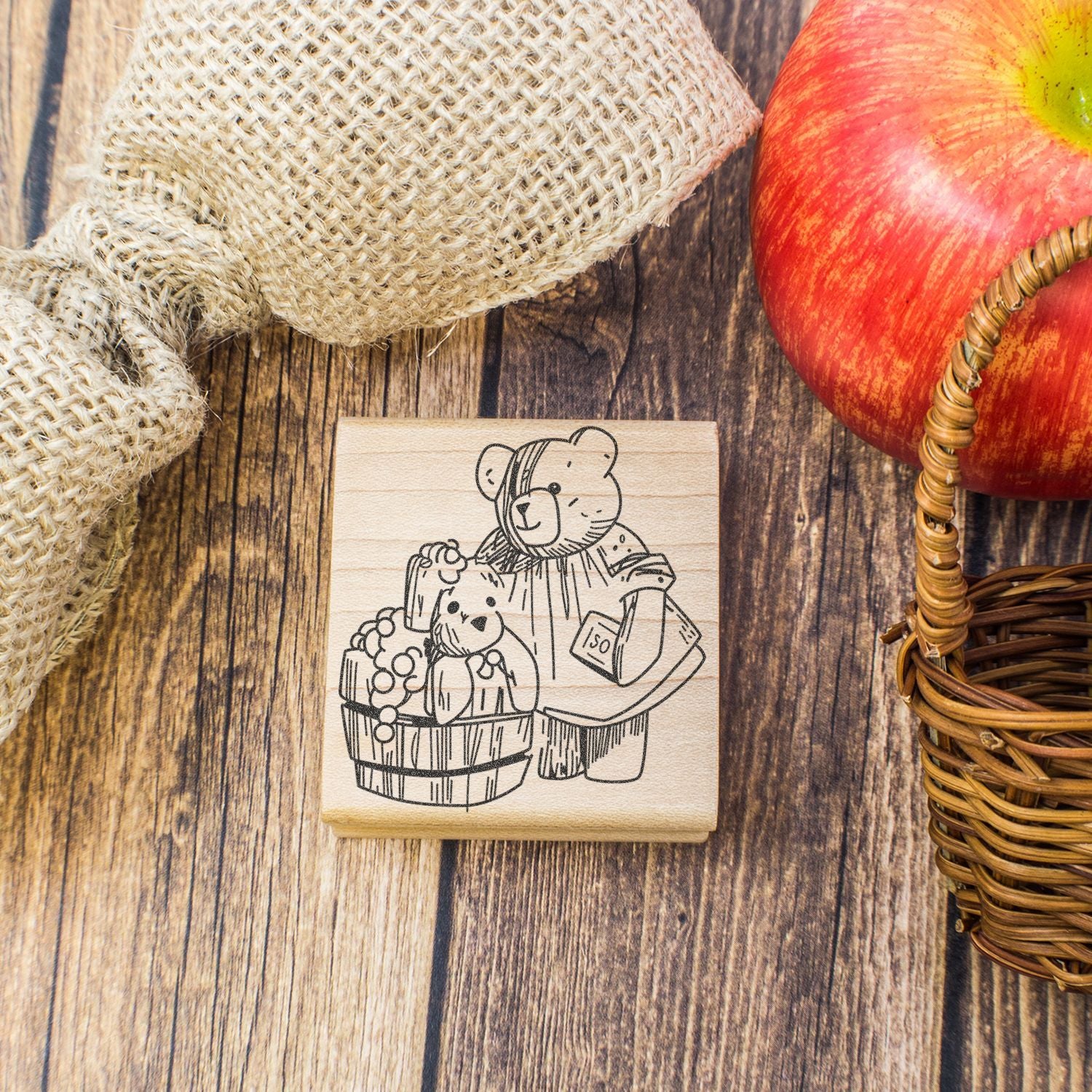 Wooden teddy bear stamp with apple harvest and rustic fall decor on a wood background