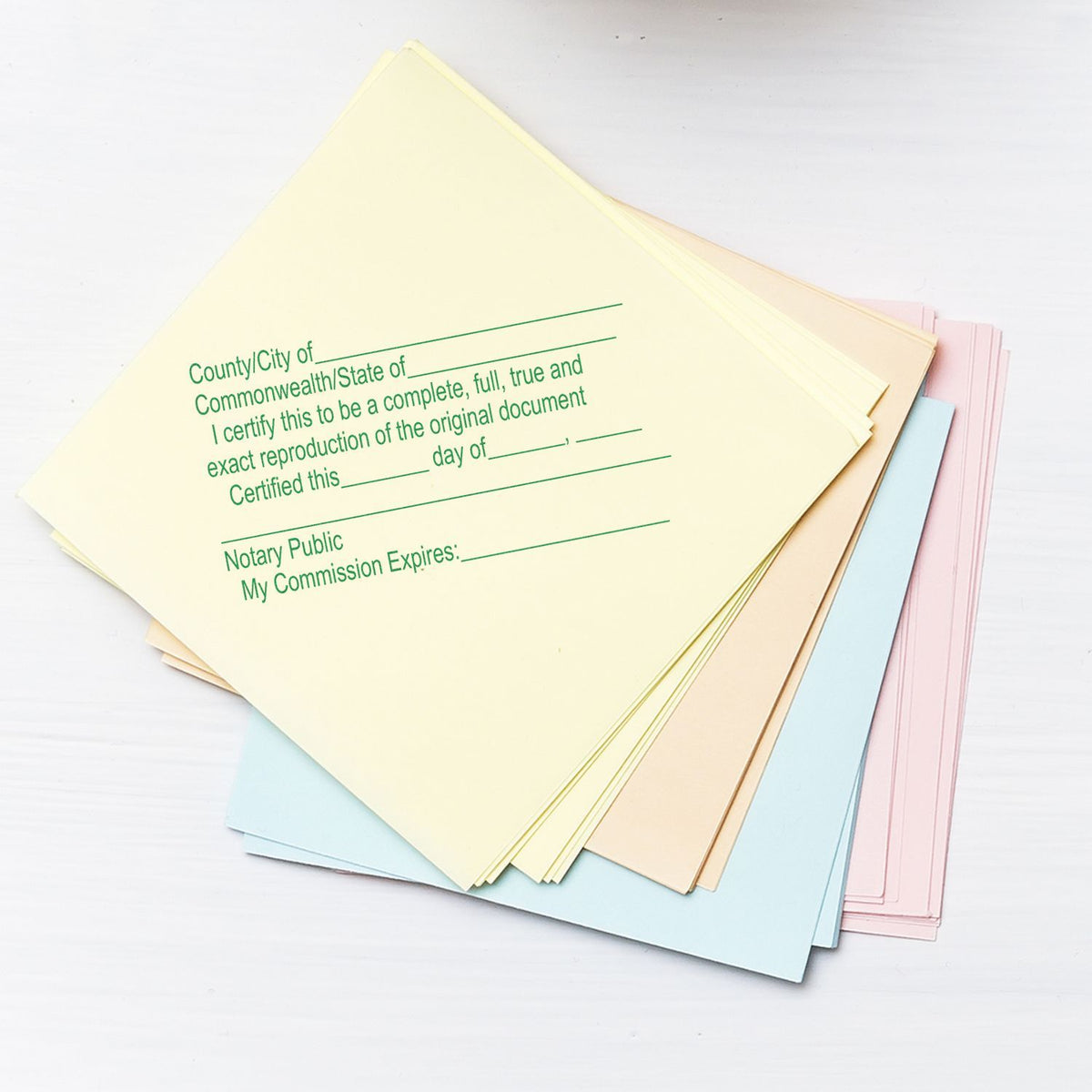 Stack of pastel notary public certificate forms and document papers on a white background