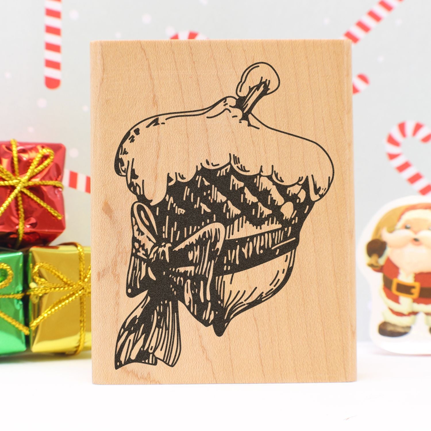 Wooden Halloween pumpkin stamp block with festive gift boxes and Santa decoration in the background