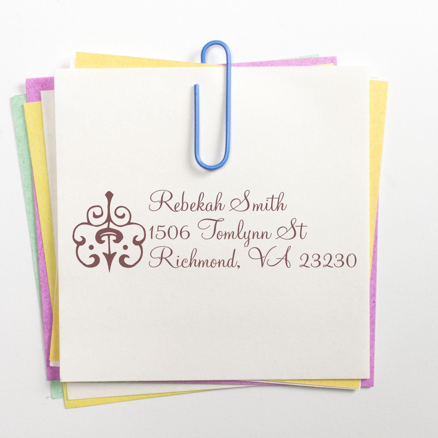 Personalized return address rubber stamp on stationery stack, with monogram design for envelopes, invitations, and mailing.
