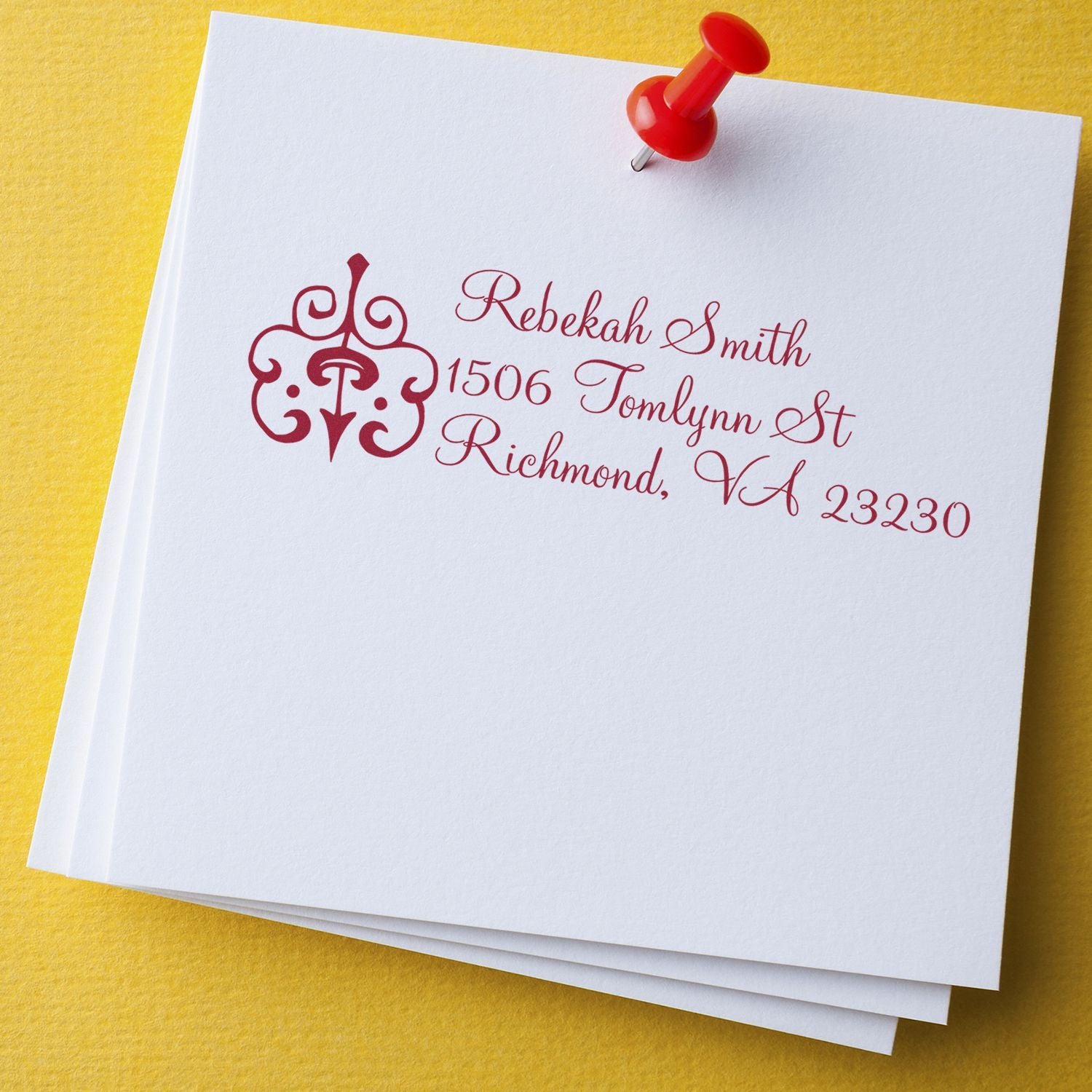 Personalized return address rubber stamp with monogram, stamped in red ink on white cardstock for mailing labels
