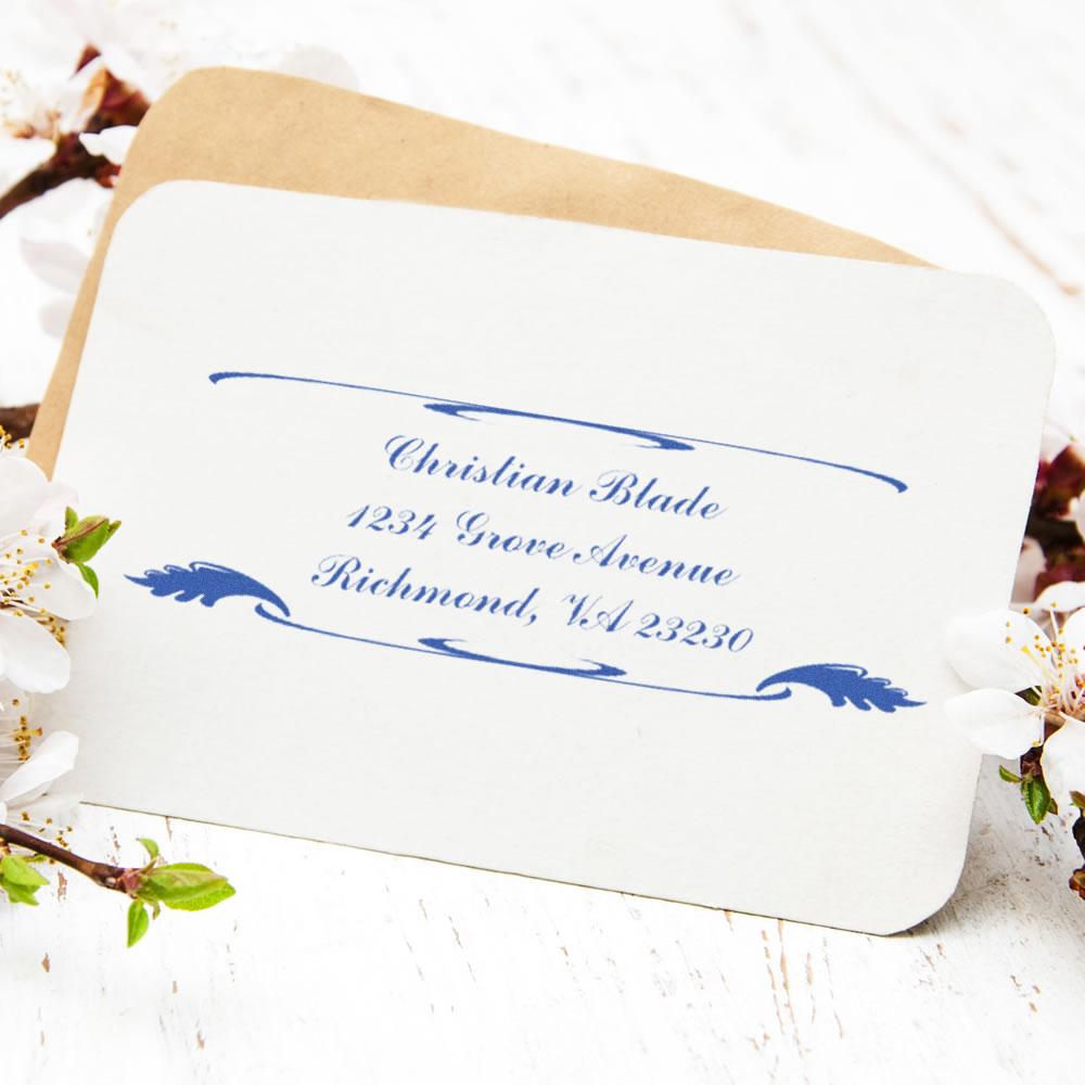Custom rubber return address stamp on envelope with blue personalized name and address imprint.