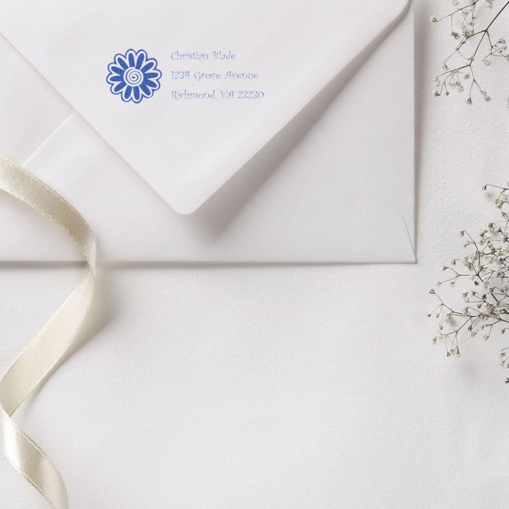 White envelope with blue floral return address rubber stamp, ideal for elegant custom wedding stationery and mailings.