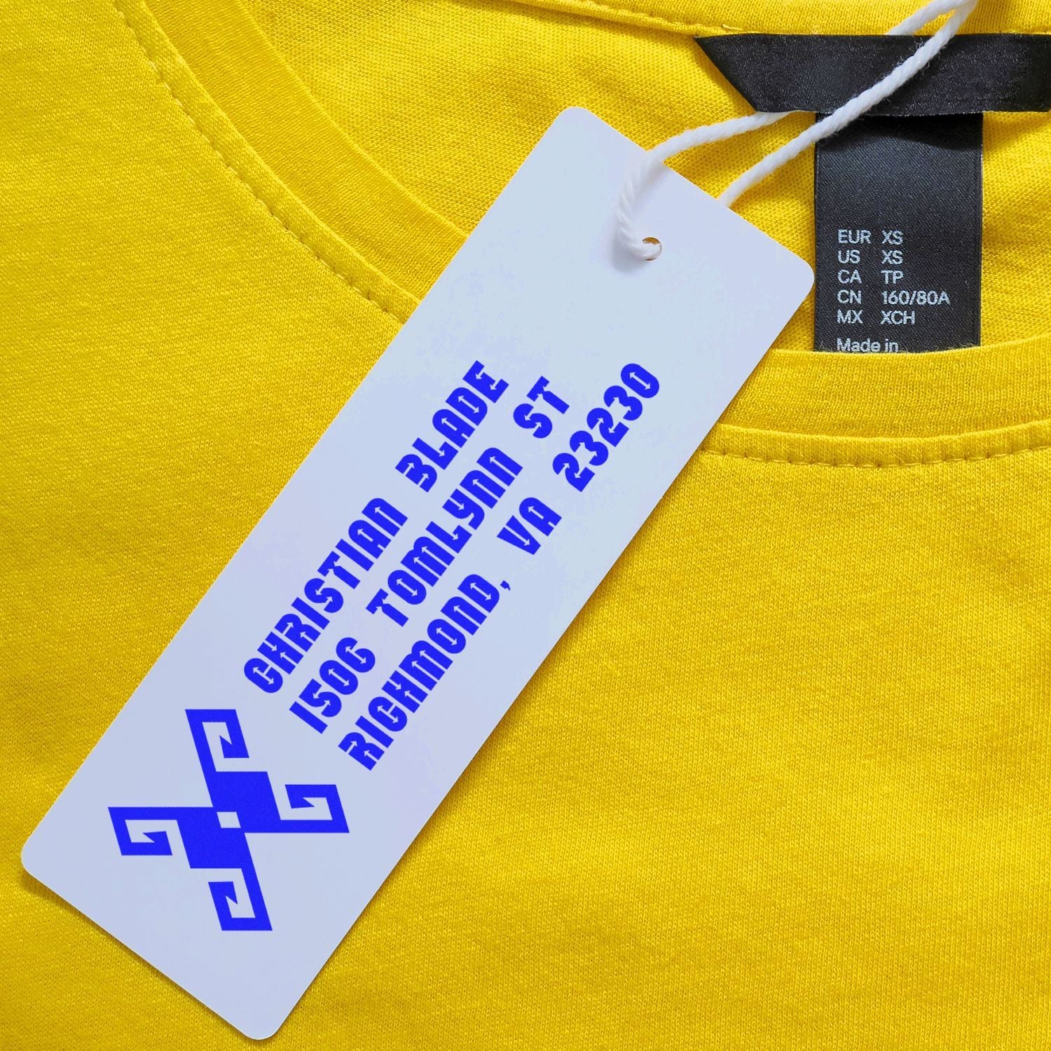 Custom rubber stamp logo on clothing tag for yellow T-shirt apparel branding and size labeling