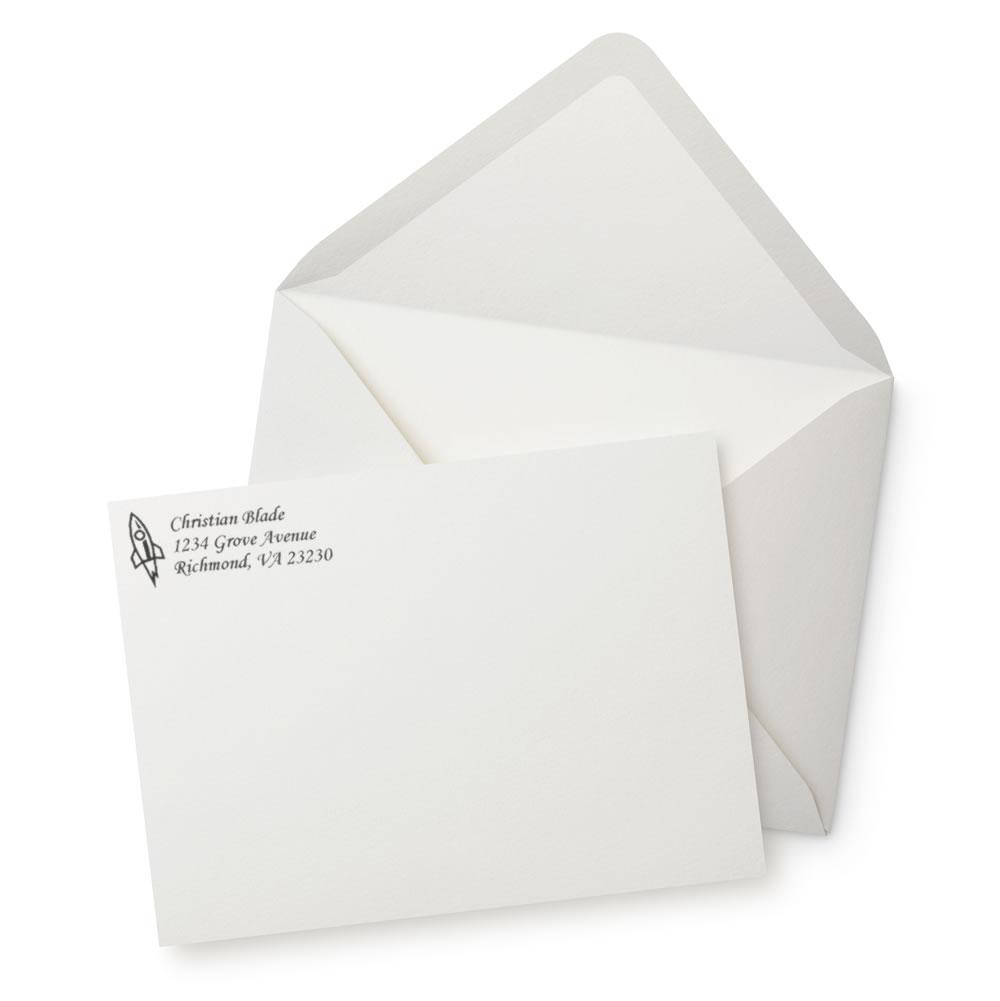 Custom return address rubber stamp on white envelope, featuring a rocket icon and personalized address for mail and business use