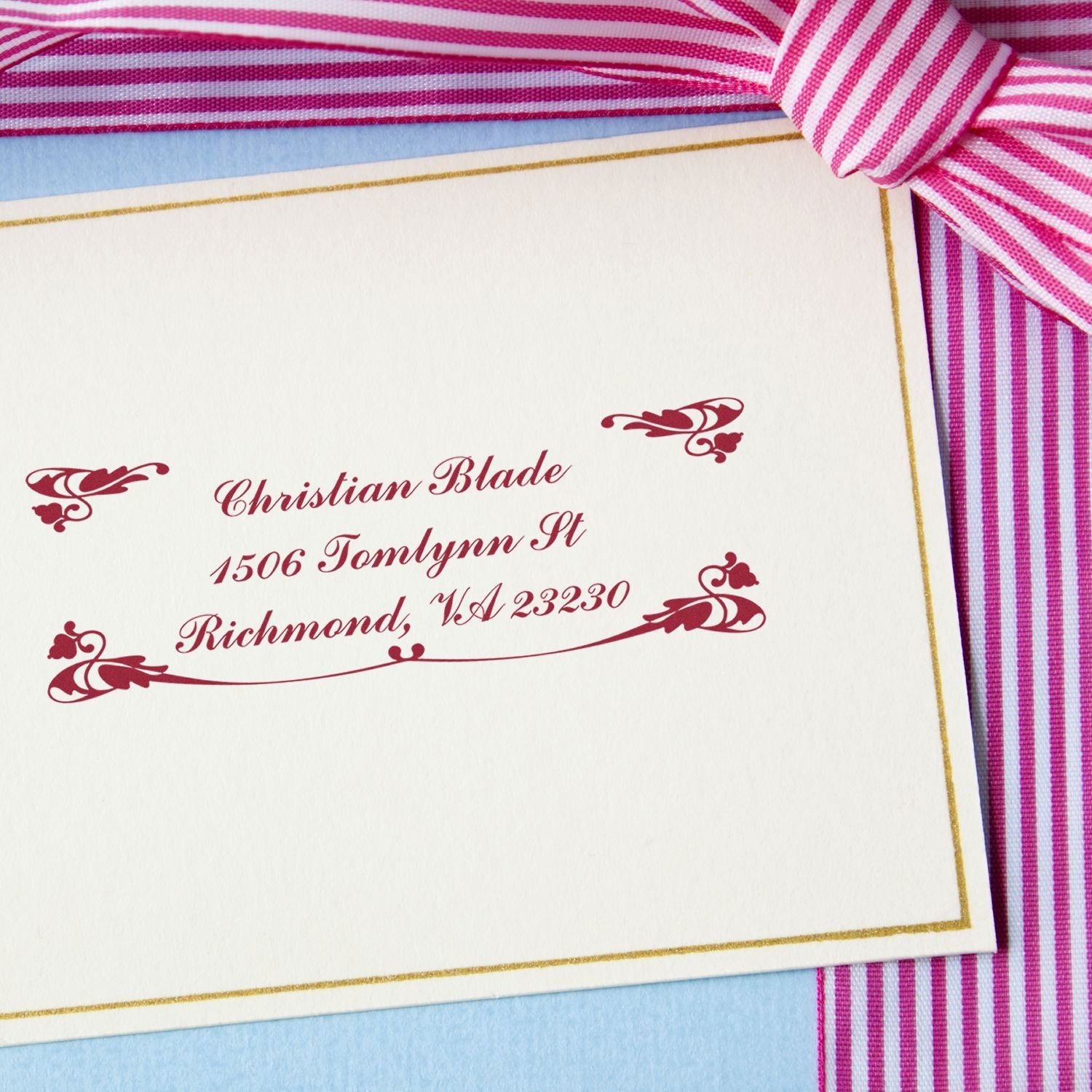 Custom return address rubber stamp on elegant wedding invitation, featuring decorative script and flourishes.