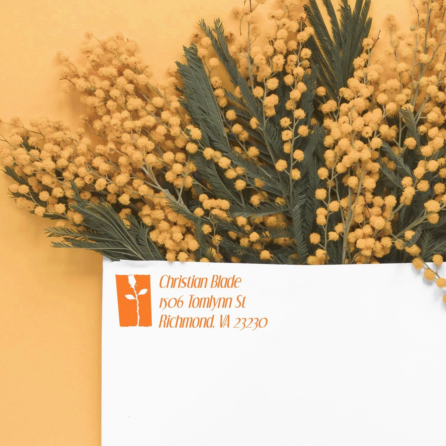 Custom rubber return address stamp on a white envelope with floral arrangement for elegant business mailings.