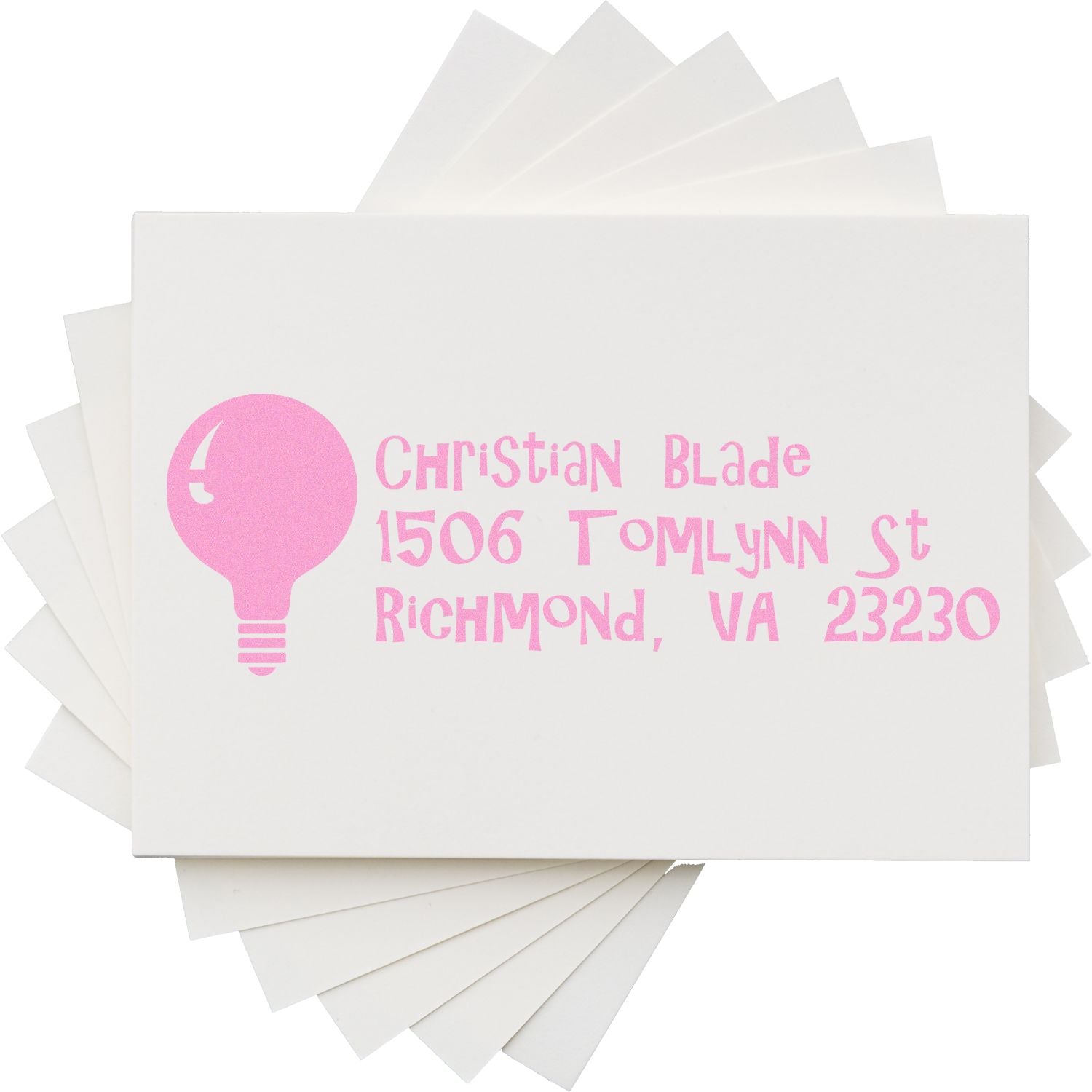 Custom pink rubber address stamp with Christian Blade, 1506 Tomlynn St, Richmond, VA 23230 on white cards.