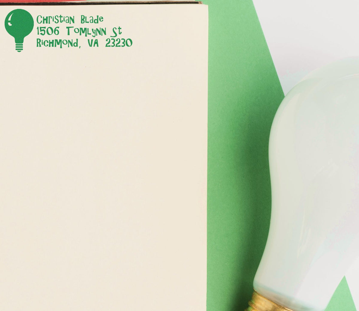 Custom address rubber stamp with light bulb logo, showing Christian Blade Richmond, VA return address on paper.